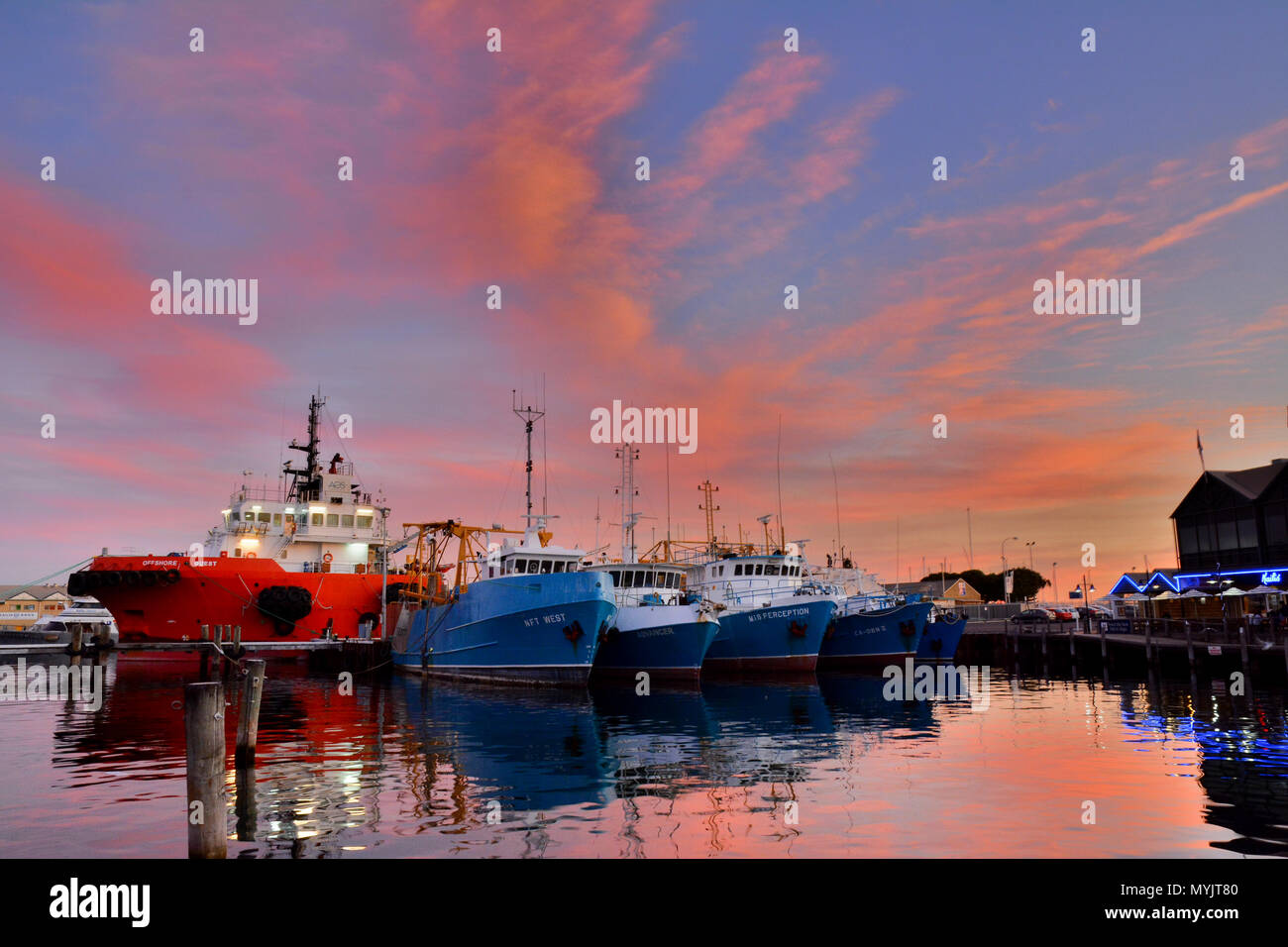 Barche in mare con le nuvole colorate al tramonto, Fremantle, Australia Foto Stock