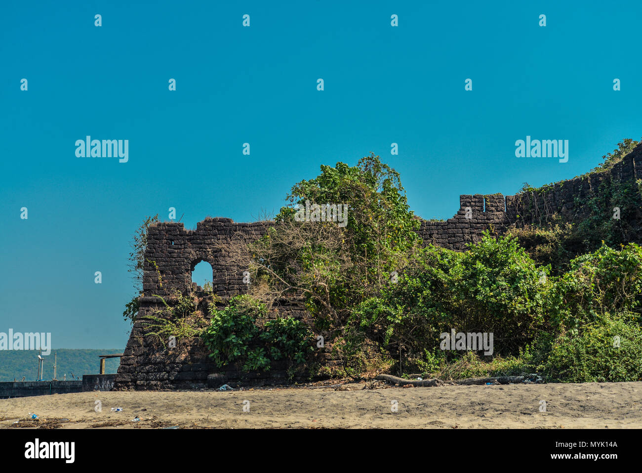 Posto vicino a Chapora molo di pesca con le rovine di un antico muro di fortificazione sulla spiaggia Chapora nel Nord Goa, India Foto Stock