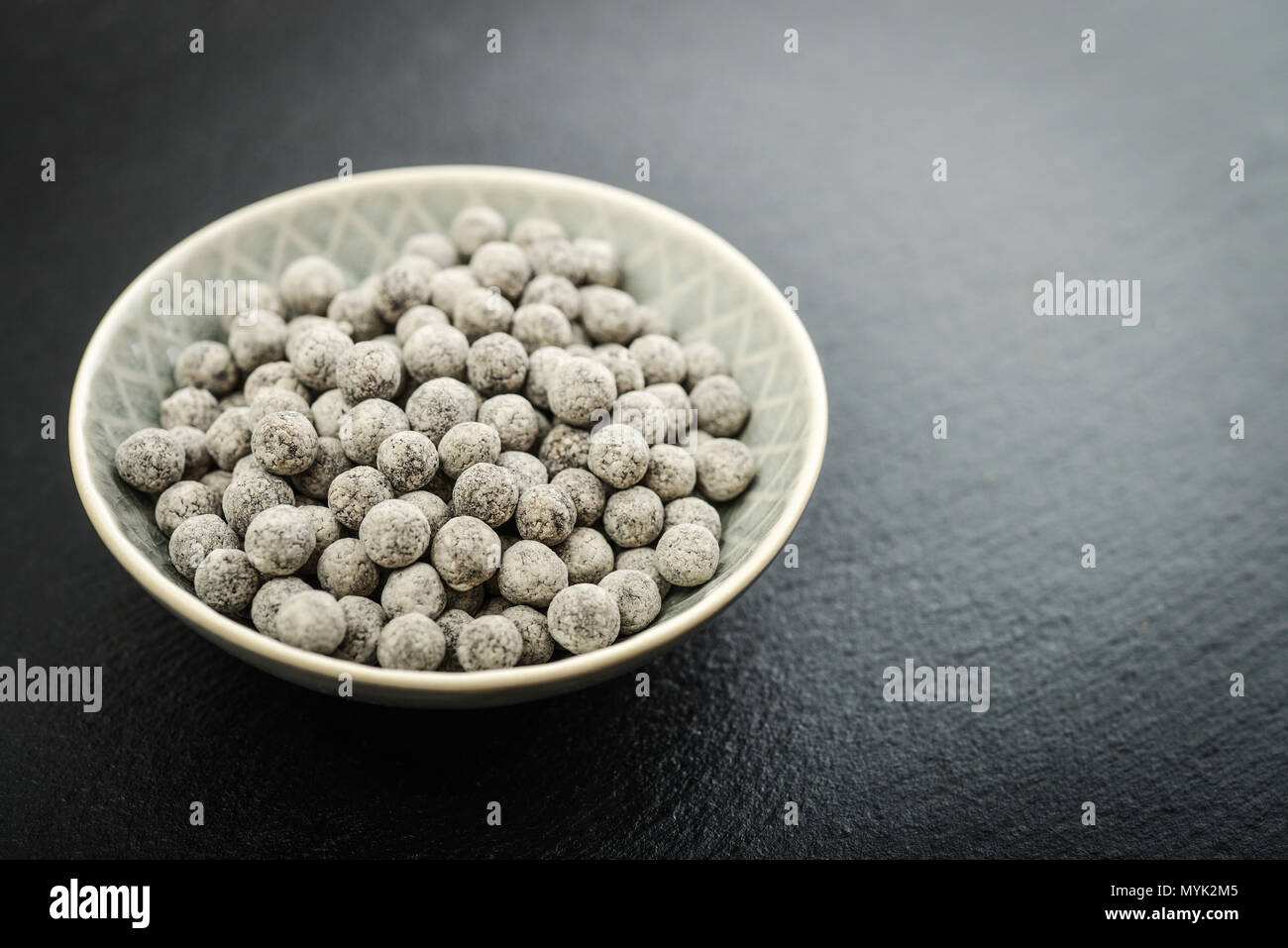 Materie Tapioca perle in piastra su nero ardesia sfondo. Per bolle di concetti di tè. Foto Stock