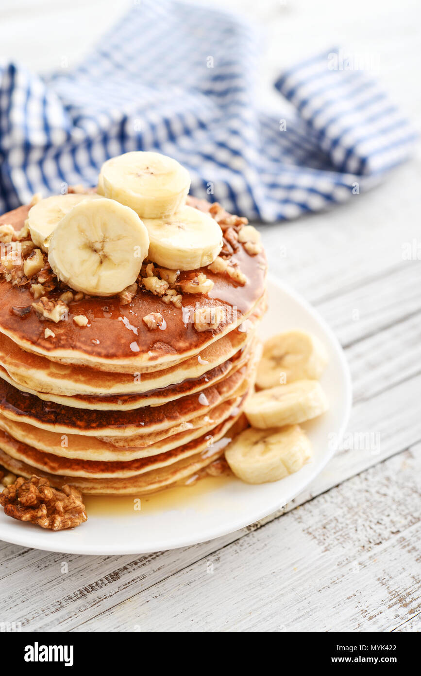 Frittelle di banane,noce e muple sciroppo per una colazione su sfondo di legno closeup Foto Stock