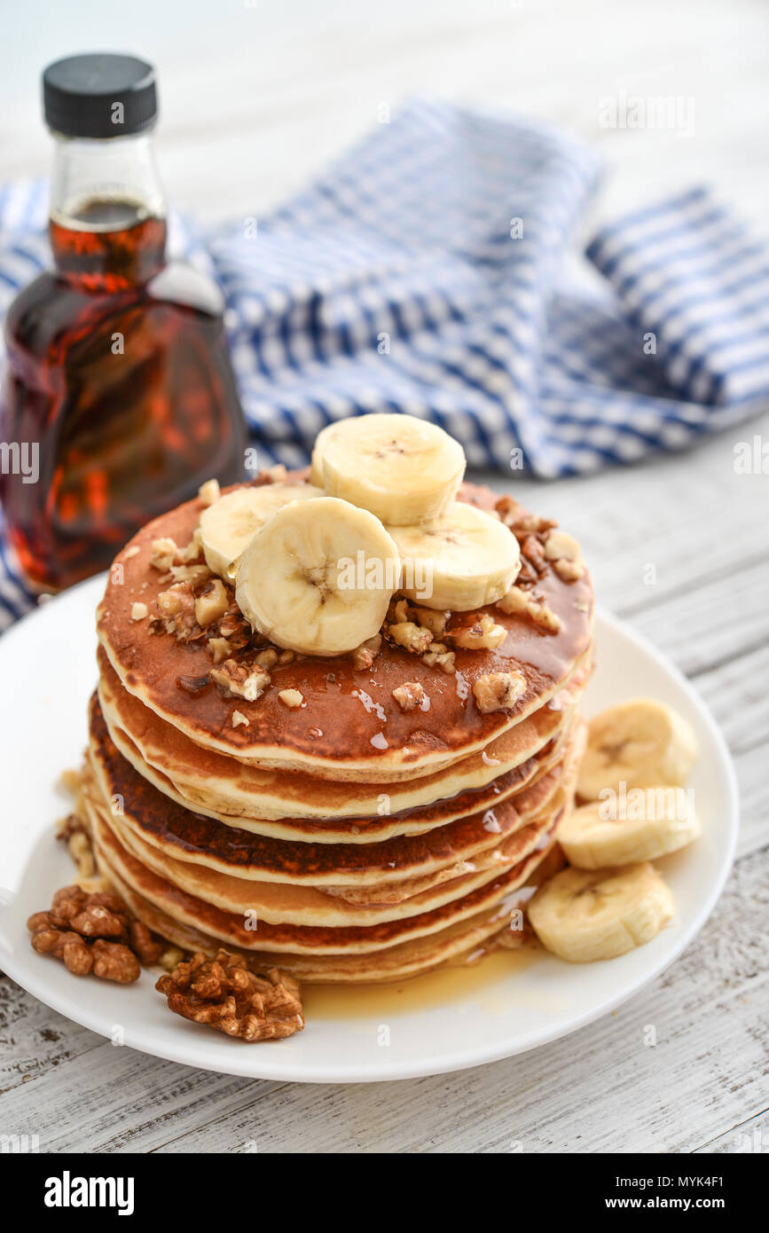 Frittelle di banane,noce e muple sciroppo per una colazione su sfondo di legno closeup Foto Stock