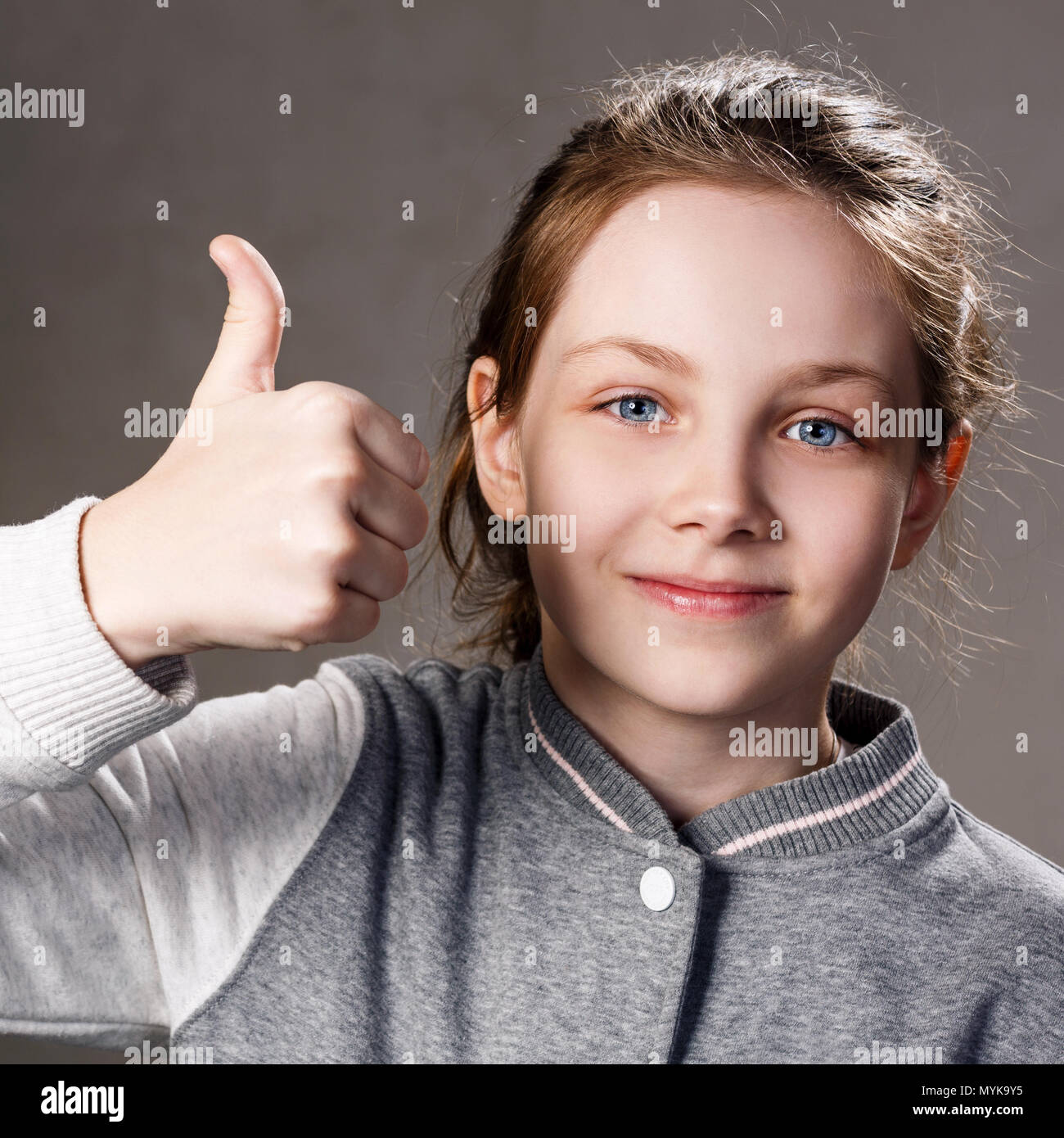 Bella ragazza smilling mostra Thumbs up gesto. Foto Stock