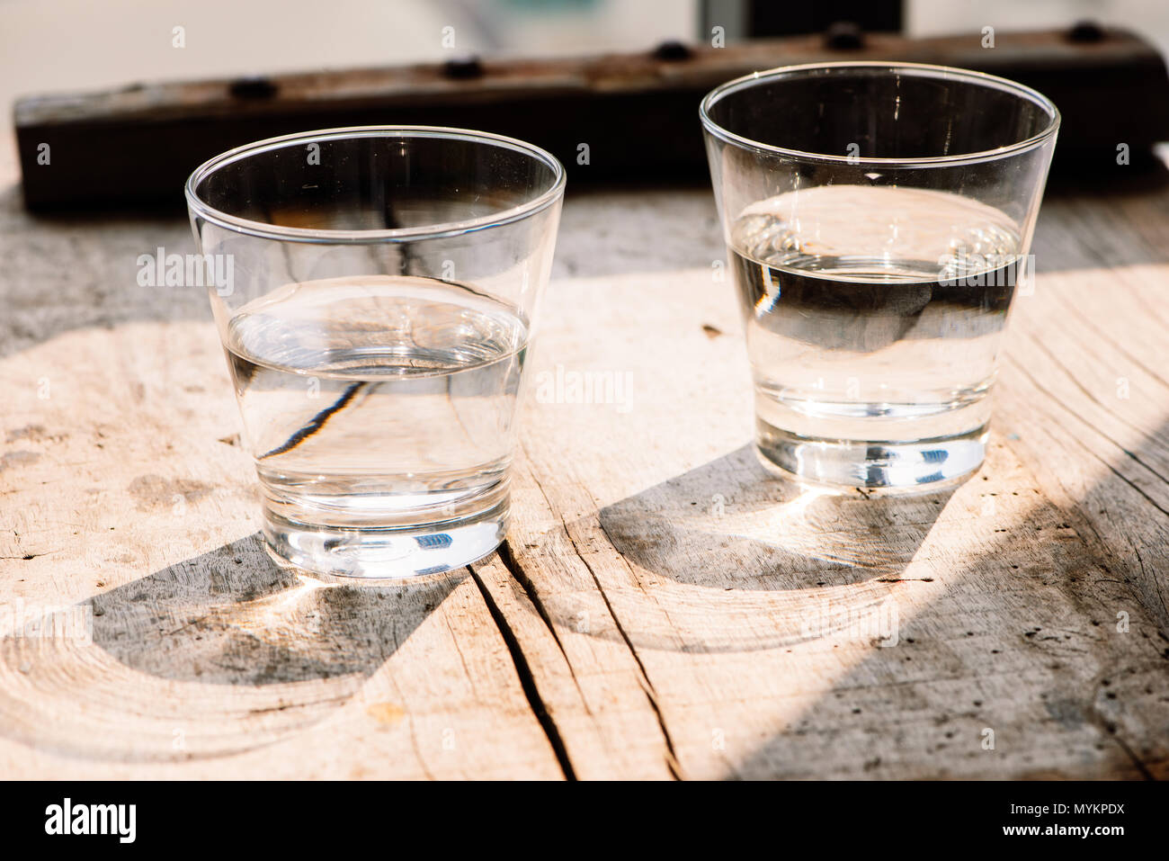 Due bicchieri di acqua sulla tavola su sfondo di legno Foto Stock