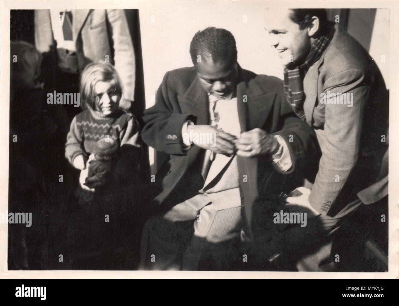 Unica fotografia informale di Louis Armstrong con uomo sorridente e la bambina stringe la bambola. Fotografia proviene da un danese del musicista album privato e fu probabilmente realizzata nel 1933 quando Armstrong ha giocato a Copenaghen con musicisti locali, incluso l'uomo sulla destra. La bambina è sua figlia; purtroppo i loro nomi non sono registrate. Foto Stock