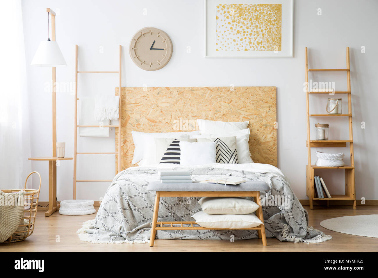 Letto matrimoniale confortevole in piedi tra le due scale in una camera monocromatica interno Foto Stock
