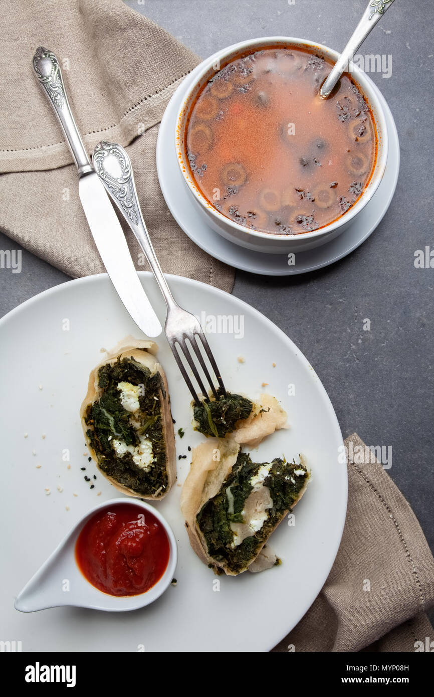 Cena con lo strudel e la Minestra sulla pietra grigia sullo sfondo Foto Stock