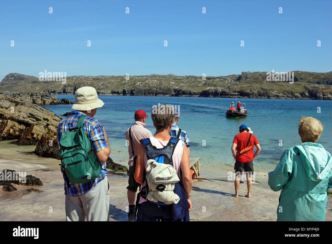 I visitatori di Handa Island, riserva naturale nazionale, in attesa di tornare a Tarbet sull'avvicinamento piccolo traghetto che atterra sulla spiaggia Foto Stock