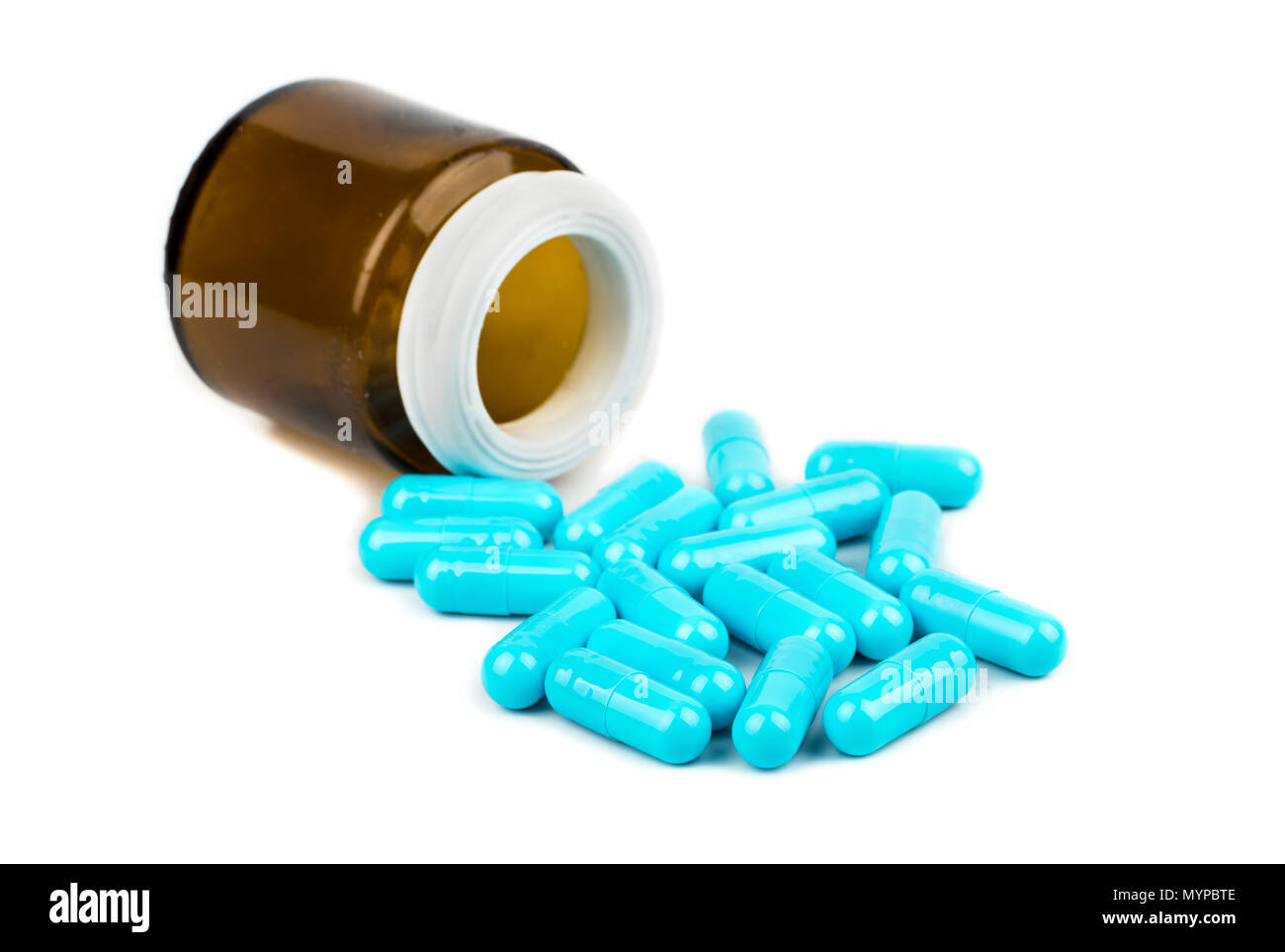 Capsule di colore blu con una bottiglia marrone su sfondo grigio Foto Stock