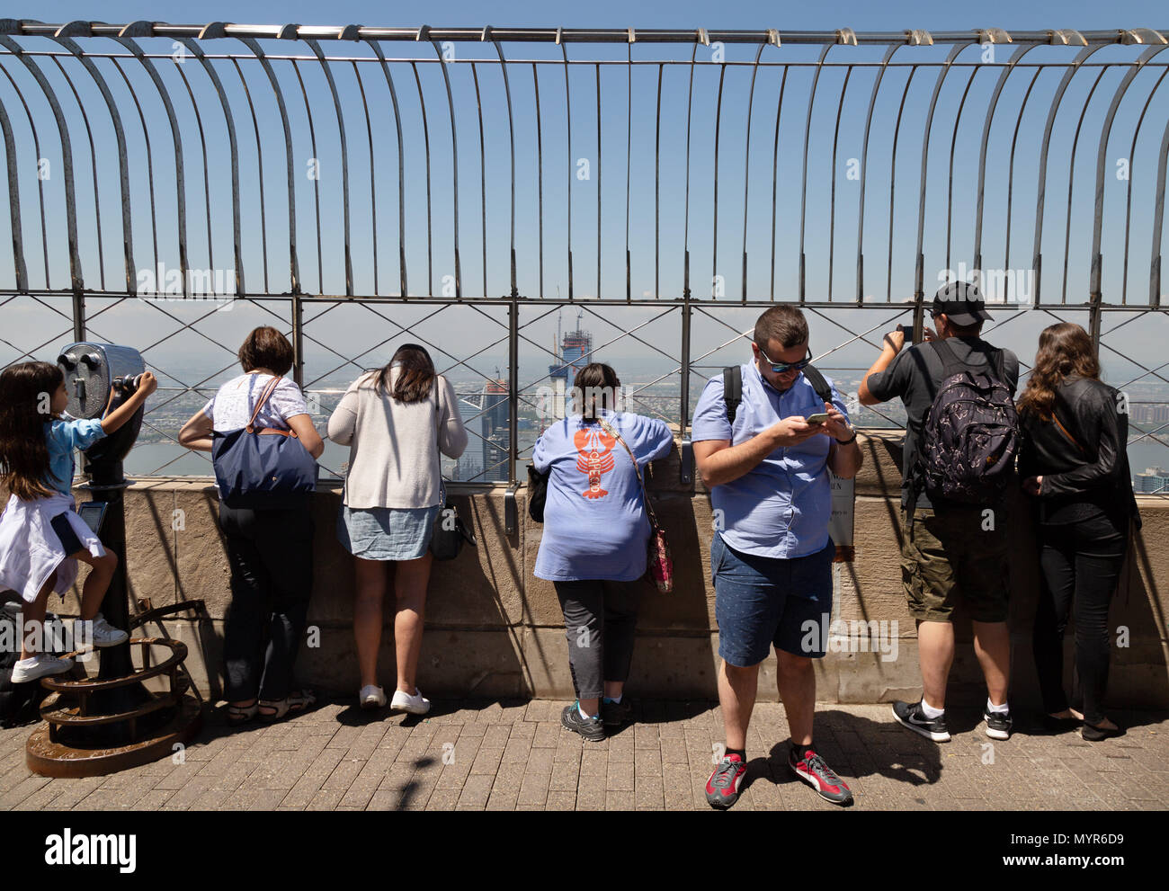 Empire State Building di New York - i turisti in cima guardando la vista di Manhattan, New York City USA Foto Stock