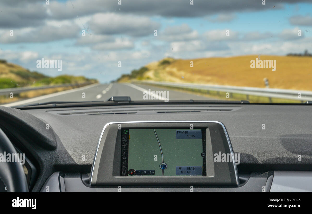 Messa a fuoco selettiva del costruito nel navigatore GPS sul cruscotto di un'auto percorrendo la panoramica autostrada in Algarve, PORTOGALLO Foto Stock