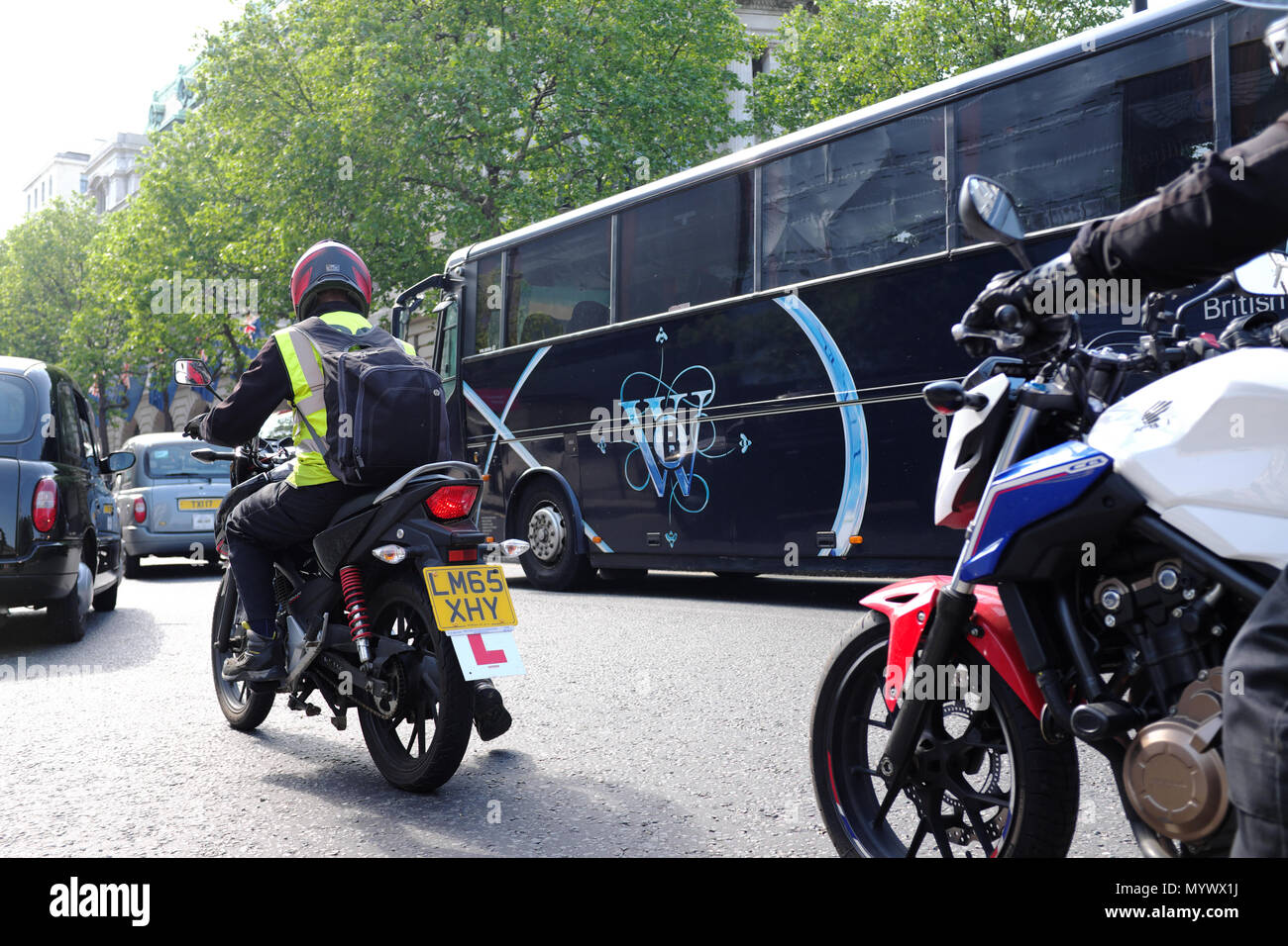 Il motociclismo tra traffico, London, England, Regno Unito Foto Stock