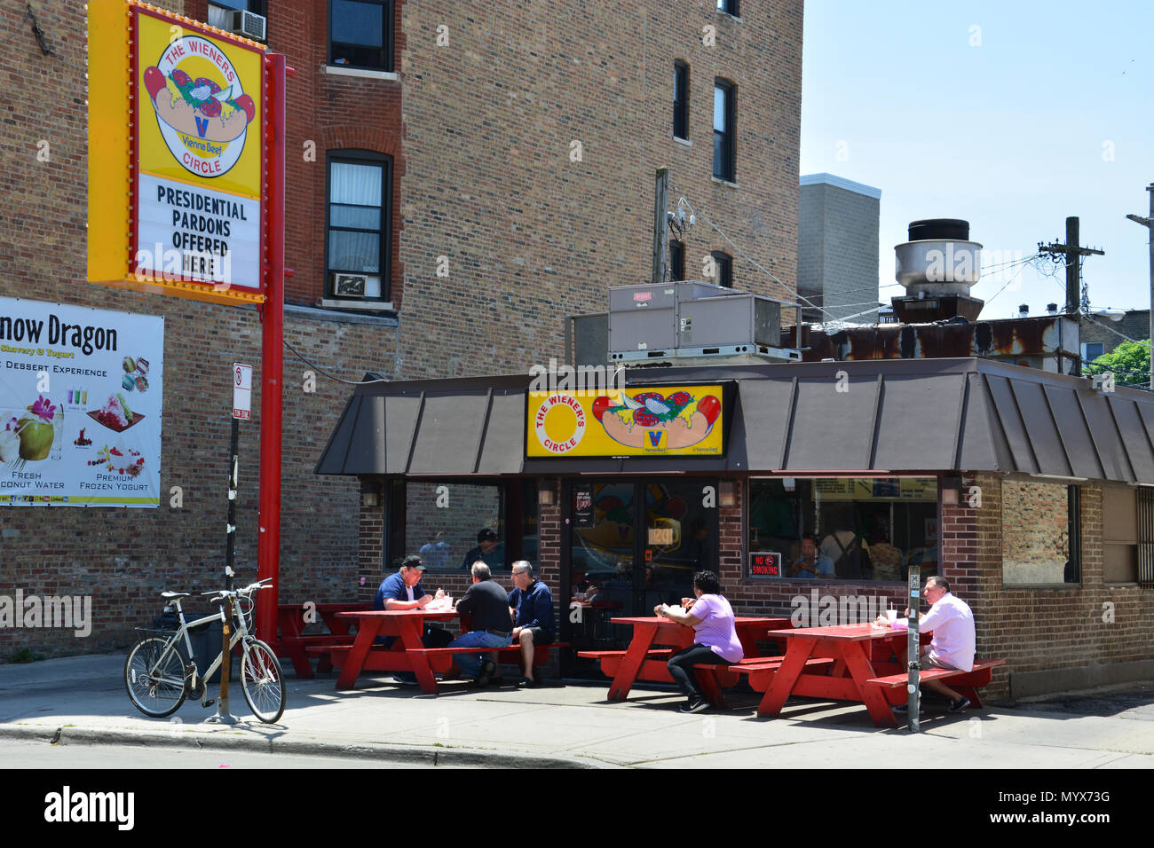 Le persone godono di uno stile di Chicago hotdog al marciapiede tavoli da picnic al di fuori del cerchio Wieners, dove essi sono famosi per imbutitura di fuori di insulti con il cibo. Foto Stock