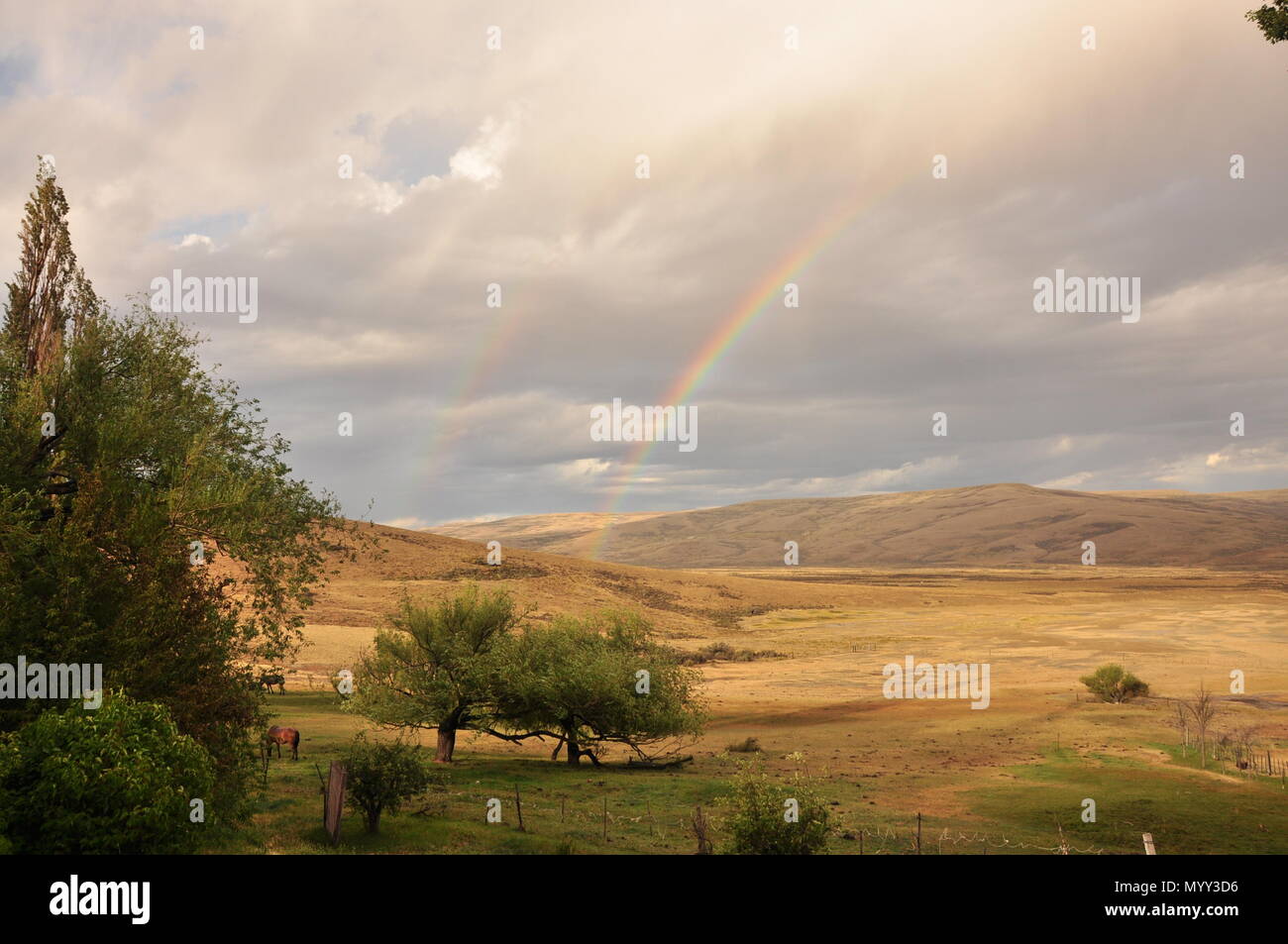 Rainbow nel campo al tramonto Foto Stock