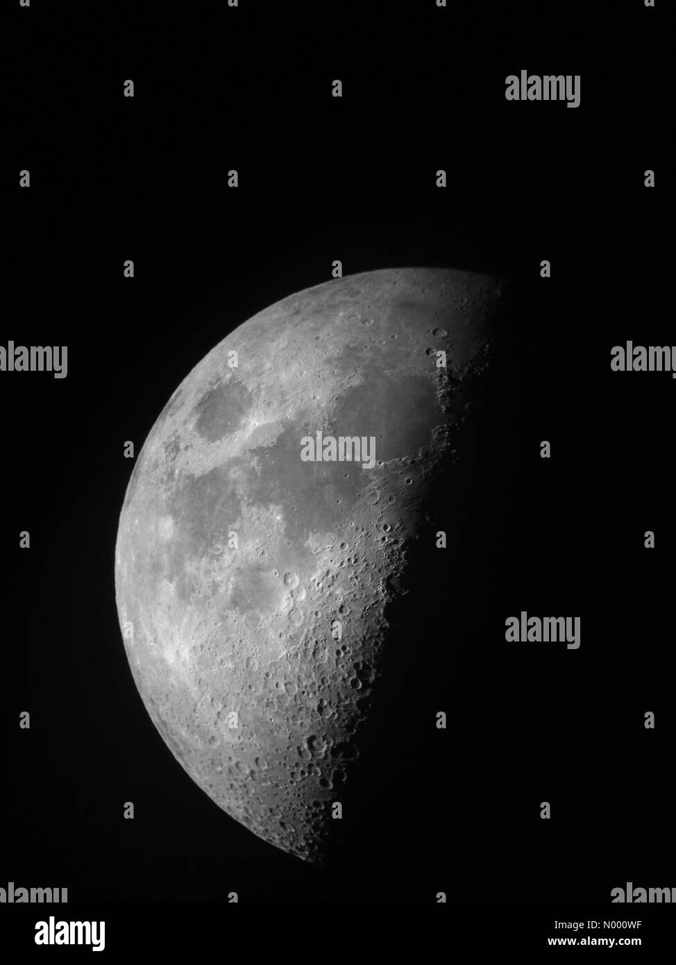 Telescopio Afocal vista presa su un iPhone tenendolo davanti a un telescopio oculare di questa notte la Luna al primo quarto, adottate il 28 dicembre 2014 a Leeds, Yorkshire. Foto Stock