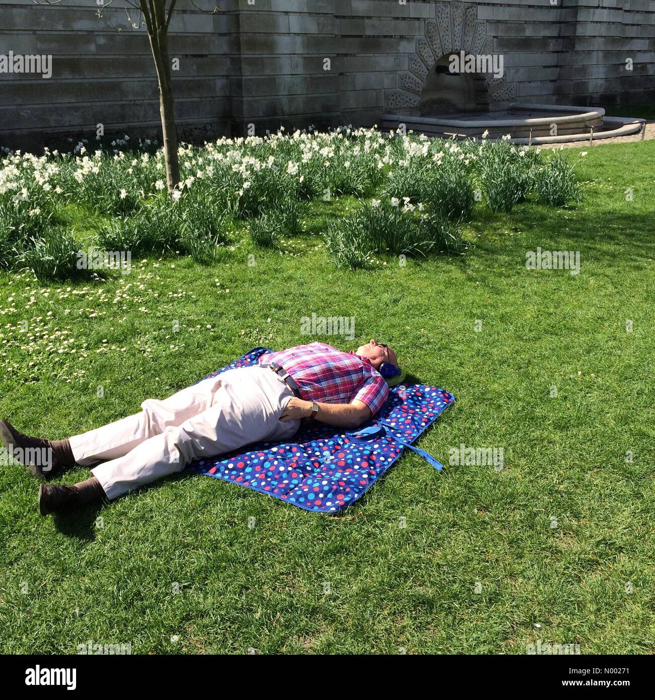 Londra, Regno Unito. Xv Apr, 2015. Un uomo giace sull'erba godendo il unseasonably calda primavera meteo. St James Park, Londra, Aprile 2015 Credit: Timothy Budd/StockimoNews/Alamy Live News Foto Stock