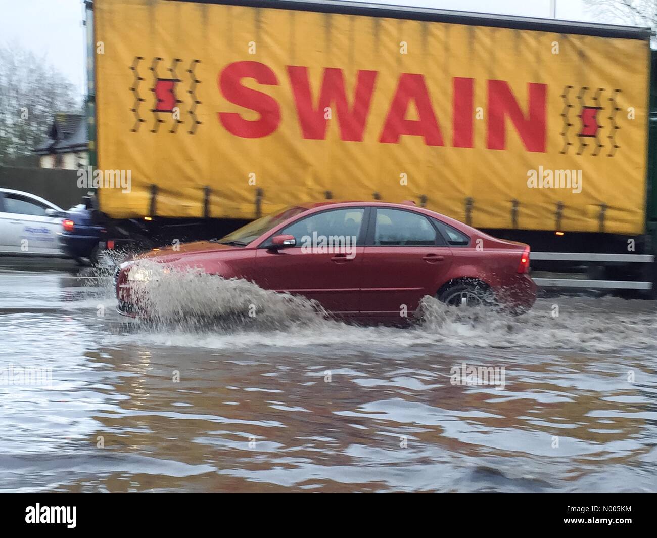 London Rd, Aylesford, Kent, Regno Unito. Xi gen, 2016. Una Volvo Car schizzi attraverso le profonde acqua di inondazione sulla A20 a Aylesford, vicino a Maidstone nel Kent, UK Credit: Matthew Richardson/StockimoNews/Alamy Live News Foto Stock