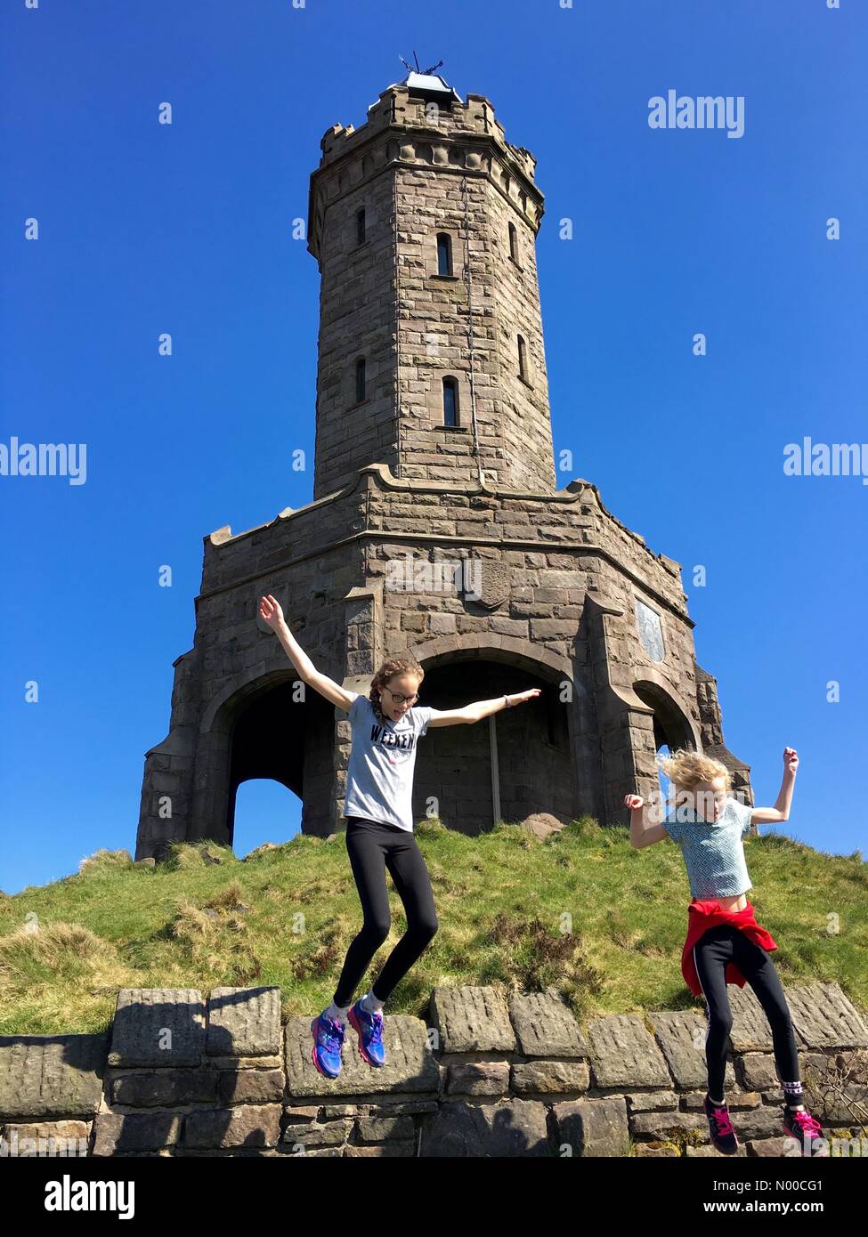 Regno Unito meteo: giornata di sole a Blackburn Lancashire. Due ragazze divertimento al sole a Darwen Giubileo torre sul mori sopra Blackburn. Foto Stock