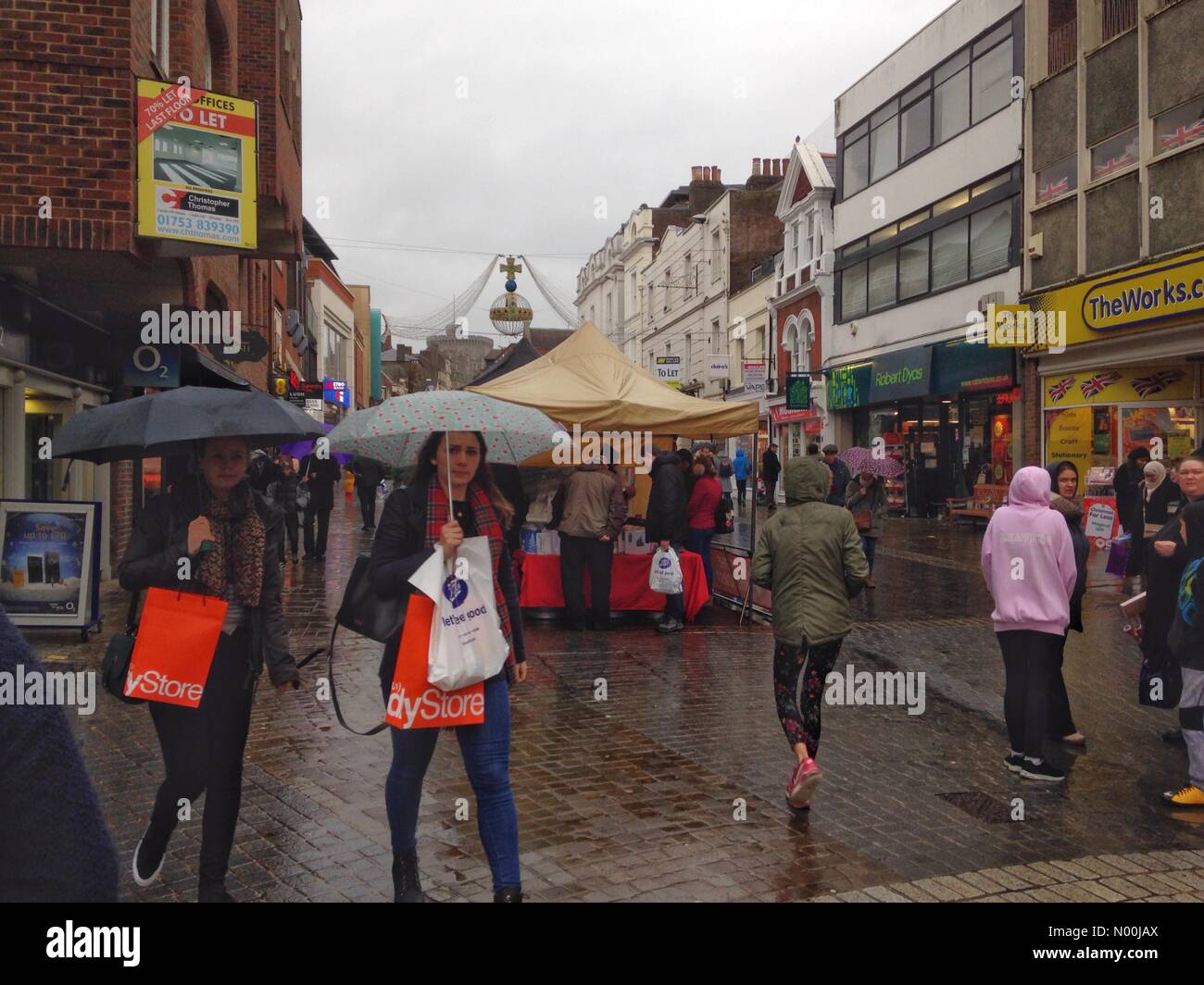 Regno Unito: Meteo Shoppers brave sul bagnato e pioggia in Windsor, Regno Unito sul finale di domenica prima di Natale. Foto Stock