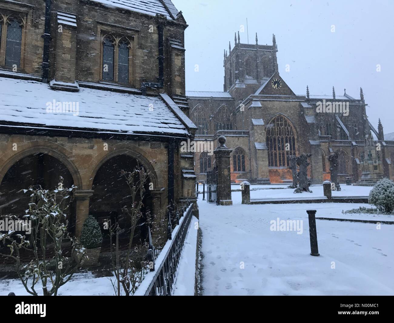 Regno Unito: Meteo Sherborne, Dorset. La neve cade su St Johns Almshouse e la storica Sherborne Abbey come i cosiddetti mini Bestia da est porta un altro gelido esplosione a sud ovest. Foto Stock