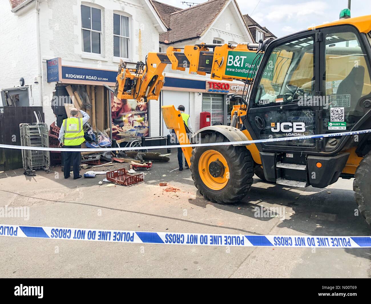 Farnham, Regno Unito. 09 Luglio, 2018. Ram raid a Tesco Express, Farnham, Surrey, Regno Unito Ridgway Road, Farnham. 09a luglio 2018. Un JCB è stata utilizzata per la ram raid il local Tesco Express store a Farnham. I ladri ha fatto fuori con un ATM. Credito: jamesjagger/StockimoNews/Alamy Live News Foto Stock