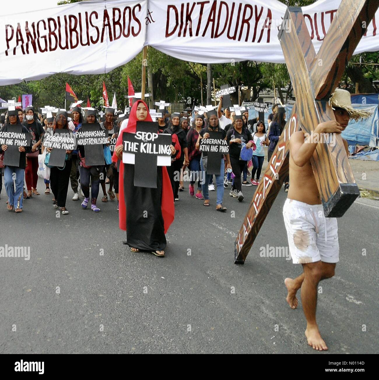 Manila, Filippine. 12 apr 2019. I gruppi militanti e vittime della droga di omicidi correlati raccolse per le strade di Manila che trasportano croce e 'stop le uccisioni' cartellone. Credito: Sherbien Dacalanio/StockimoNews/Alamy Live News Foto Stock