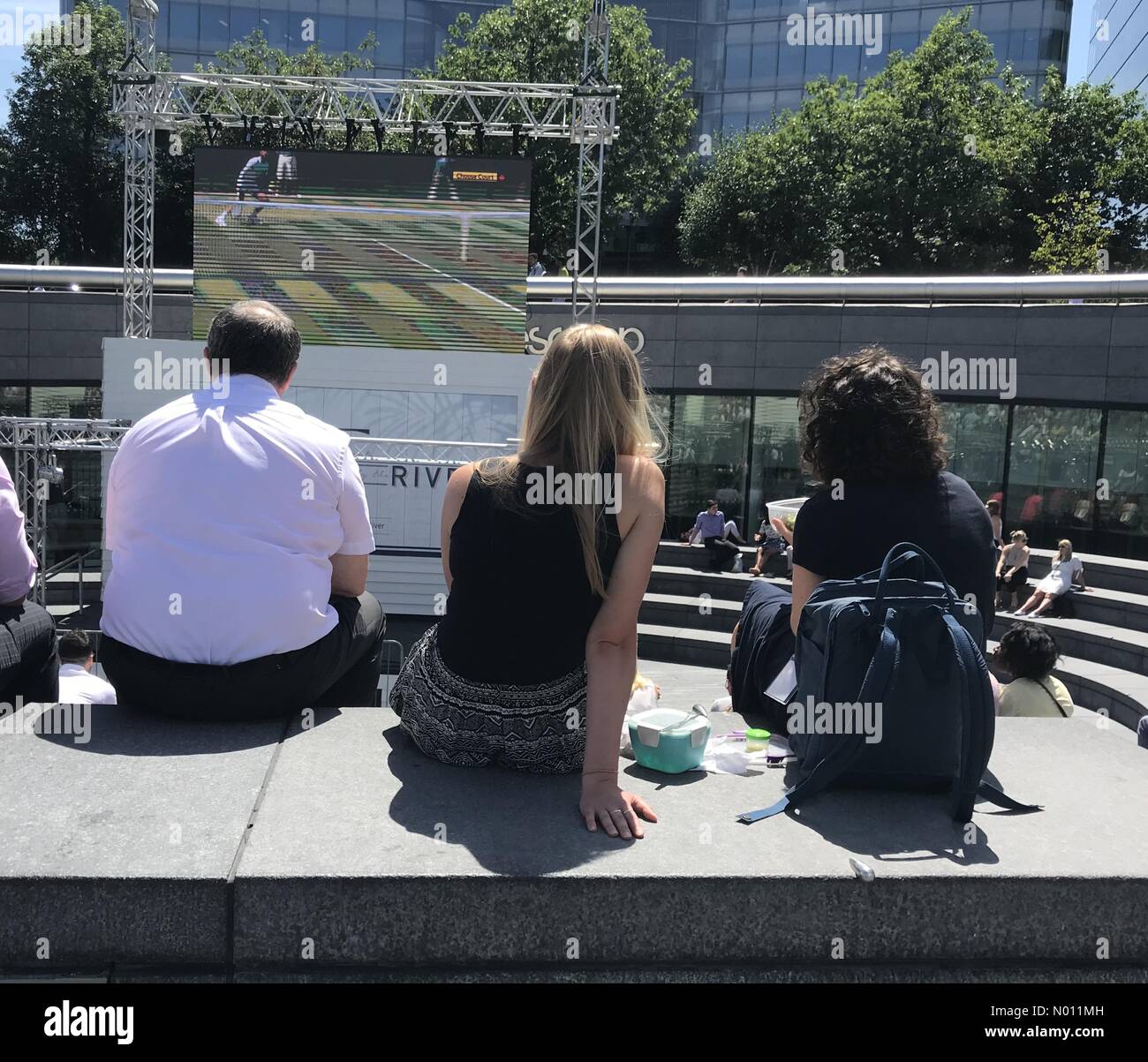 Londra, Regno Unito. 4 Luglio, 2019. Regno Unito: Meteo due donne trascorrono la loro pausa pranzo guardando Wimbledon sul grande schermo del Ponte di Londra sotto il cielo limpido. Credito: Paolo Swinney/StockimoNews/Alamy Live News Credito: Paolo Swinney/StockimoNews/Alamy Live News Foto Stock