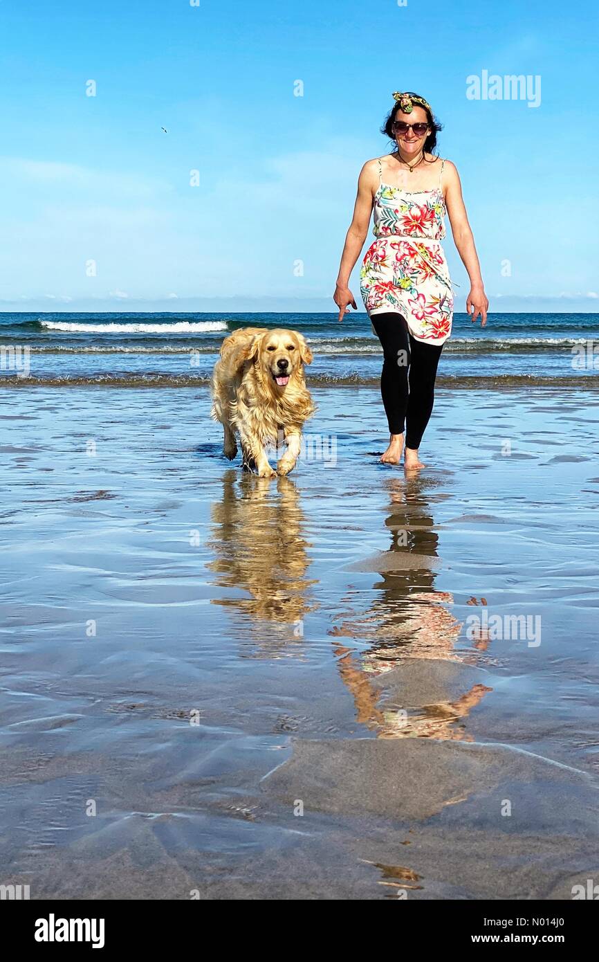 Cornovaglia, Regno Unito. Aprile 13 2021: Regno Unito Meteo: Cielo blu e sole per Raich Keene e Raffaello il Retriever sulla spiaggia di Perranporth, Cornovaglia Credit: Nidpor/StockimoNews/Alamy Live News Foto Stock