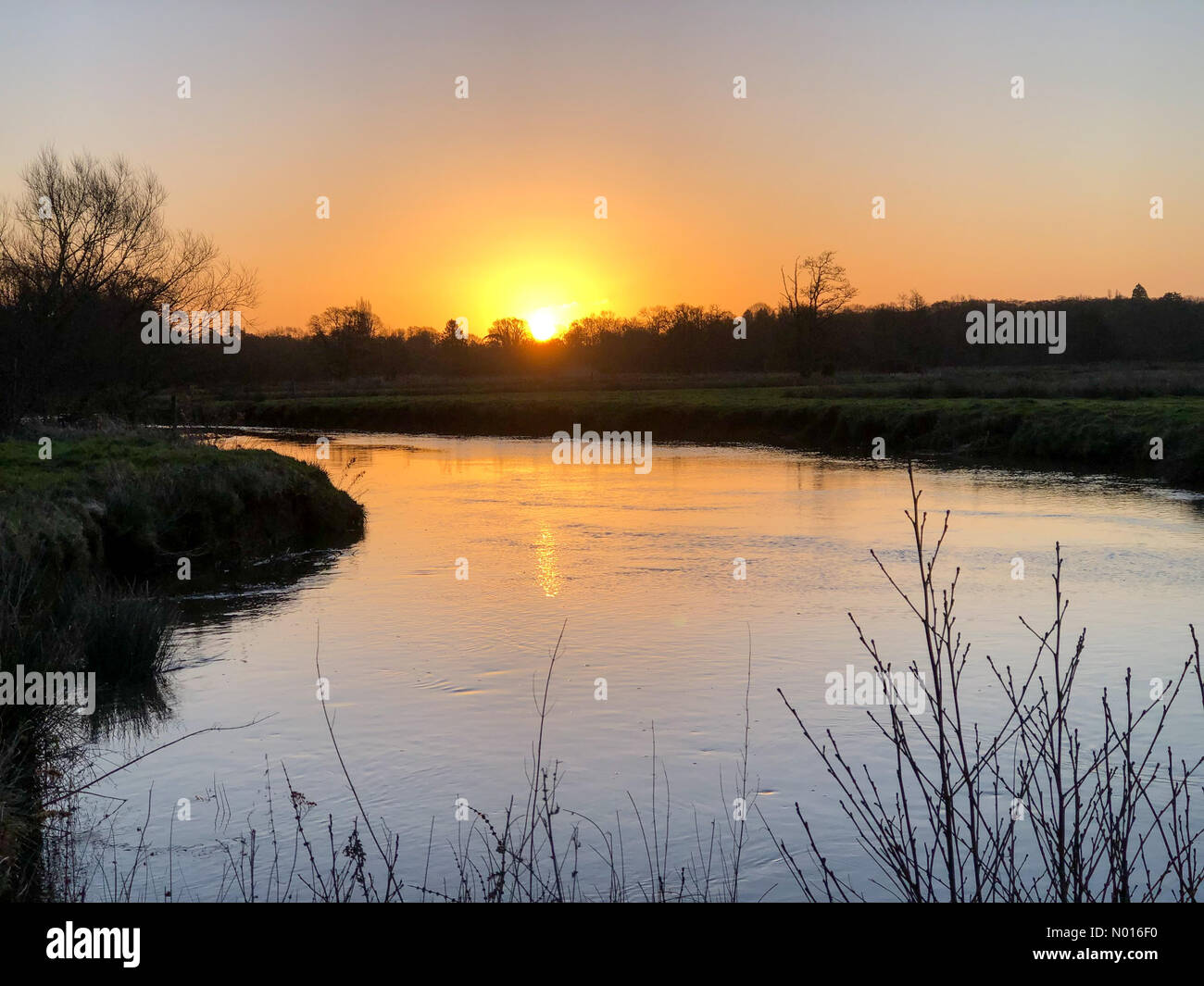 UK Meteo: Sunrise Over Elstead. Waverley Ln, Elstead. 25th febbraio 2022. Un freddo ma soleggiato inizio di giornata per le contee domestiche. Alba sul fiume Wey a Thundry Meadows, Elstead, Surrey. Credit: Jamesjagger/StockimoNews/Alamy Live News Foto Stock