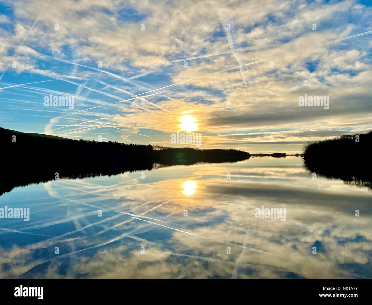 Tempo nel Regno Unito: Mattinata di sole a Rivington. Fredda mattinata invernale soleggiata con sole e nuvole riflesse nel bacino idrico di Rivington vicino a Chorley nel Lancashire Foto Stock