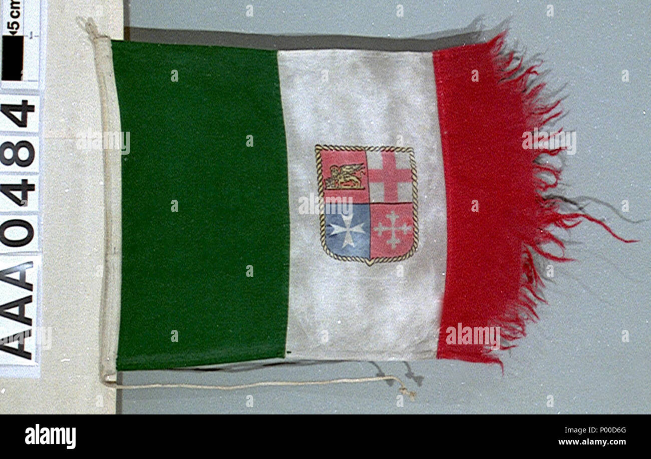 . Inglese: mercante italiano ensign (dopo 1946) Italiano merchant ensign, dopo 1946 pattern, dal Tamigi aliscafo "Freccia del Vesuvio'. La bandiera è in cotone bunting, macchina cuciti con un filo collegato per il sollevamento. Il fly bordo è molto logora. Tre strisce verticali in verde, bianco e rosso sono stampati sulla bandiera. Sulla striscia centrale di uno scudo, confina con corda in oro, con la quarterings: 1) rosso con il leone di San Marco in oro (Venezia). 2) Bianco con la croce rossa di St George (Genova). 3) blu con una Croce Maltese bianca (Amalfi). 4) rosso con croce di Pisa in bianco (Pisa). La ens Foto Stock