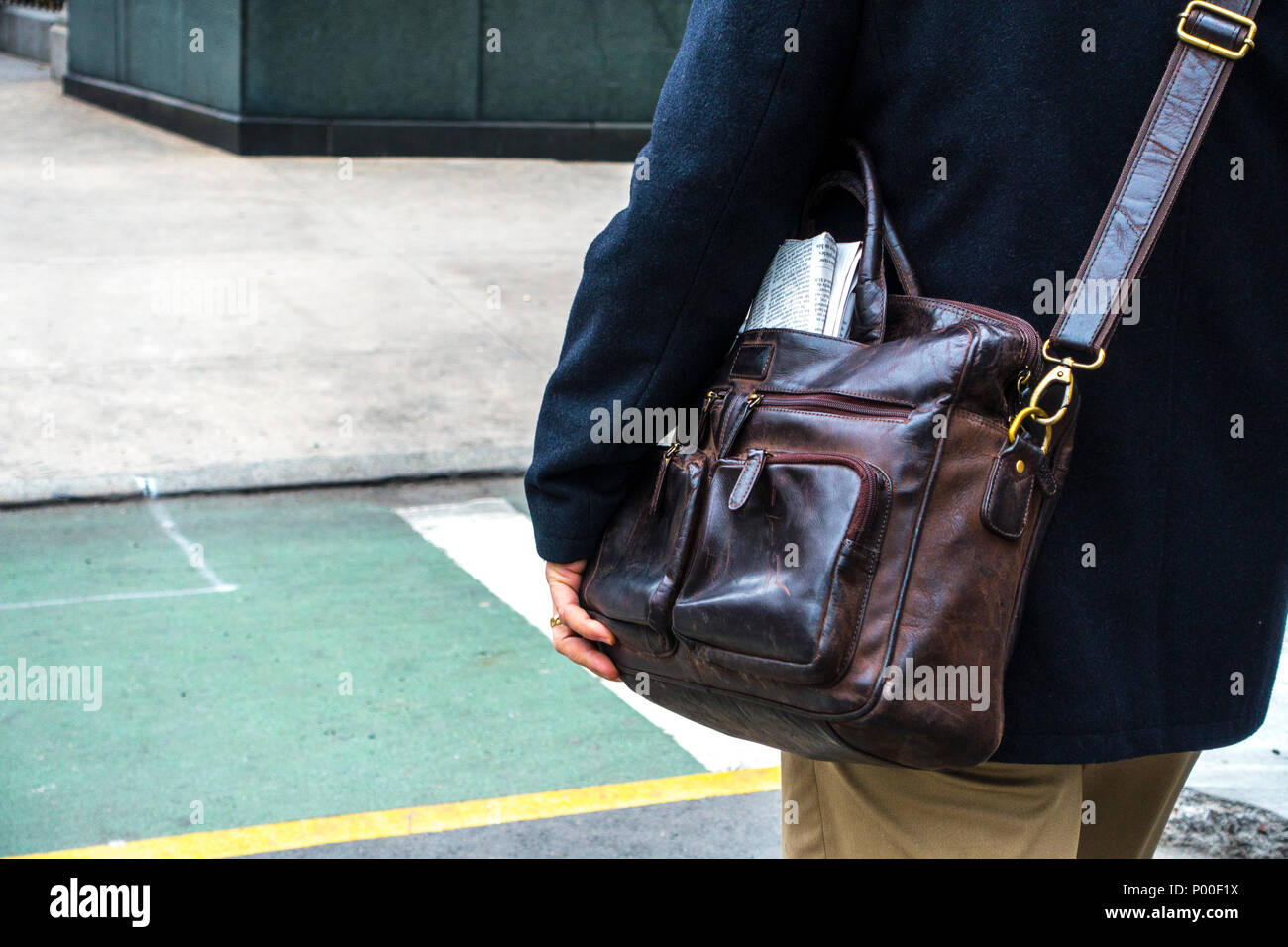 Uomo con un brazer blu e marrone chiaro con i pantaloni in pelle marrone tracolla Borsa Foto Stock