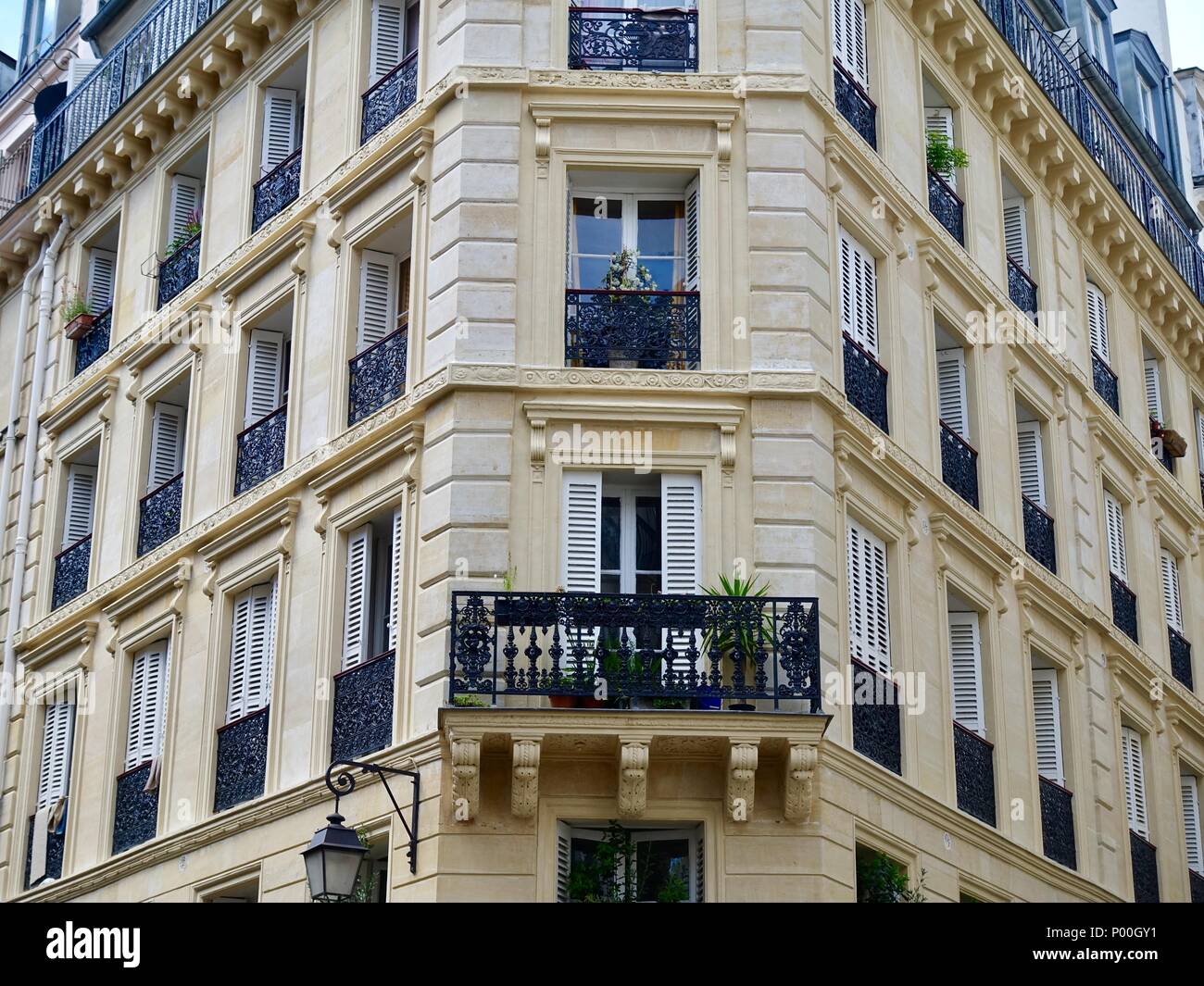 Balcone e finestre sull'angolo di un classico edificio parigino a Le Marais, Parigi, Francia Foto Stock