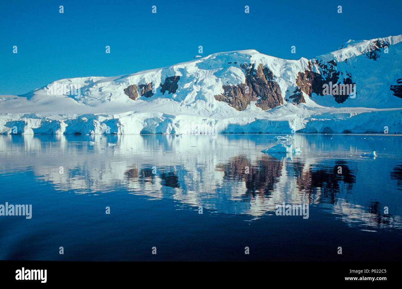 Montagne coperte di neve mirroring in Paradise Bay, penisola antartica, Antartide Foto Stock