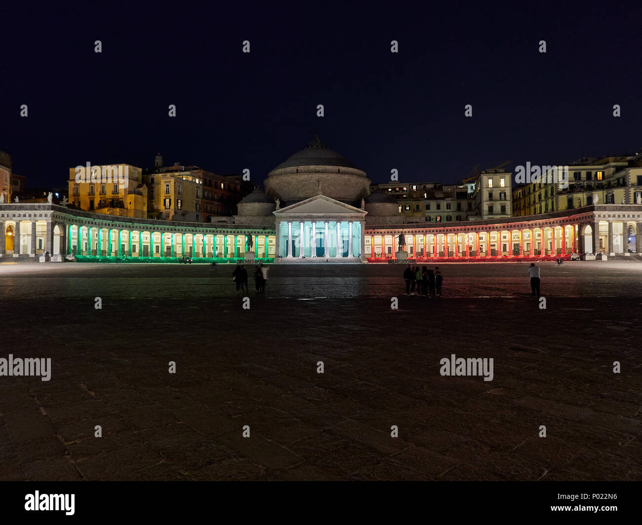 Vista panoramica di verde blu arancione illuminata di notte Piazza del Plebiscito sulla piazza con i turisti in Napoli Foto Stock