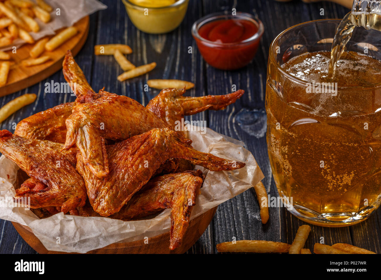 Ali di bufalo con patatine fritte e birra, il fuoco selettivo. Foto Stock