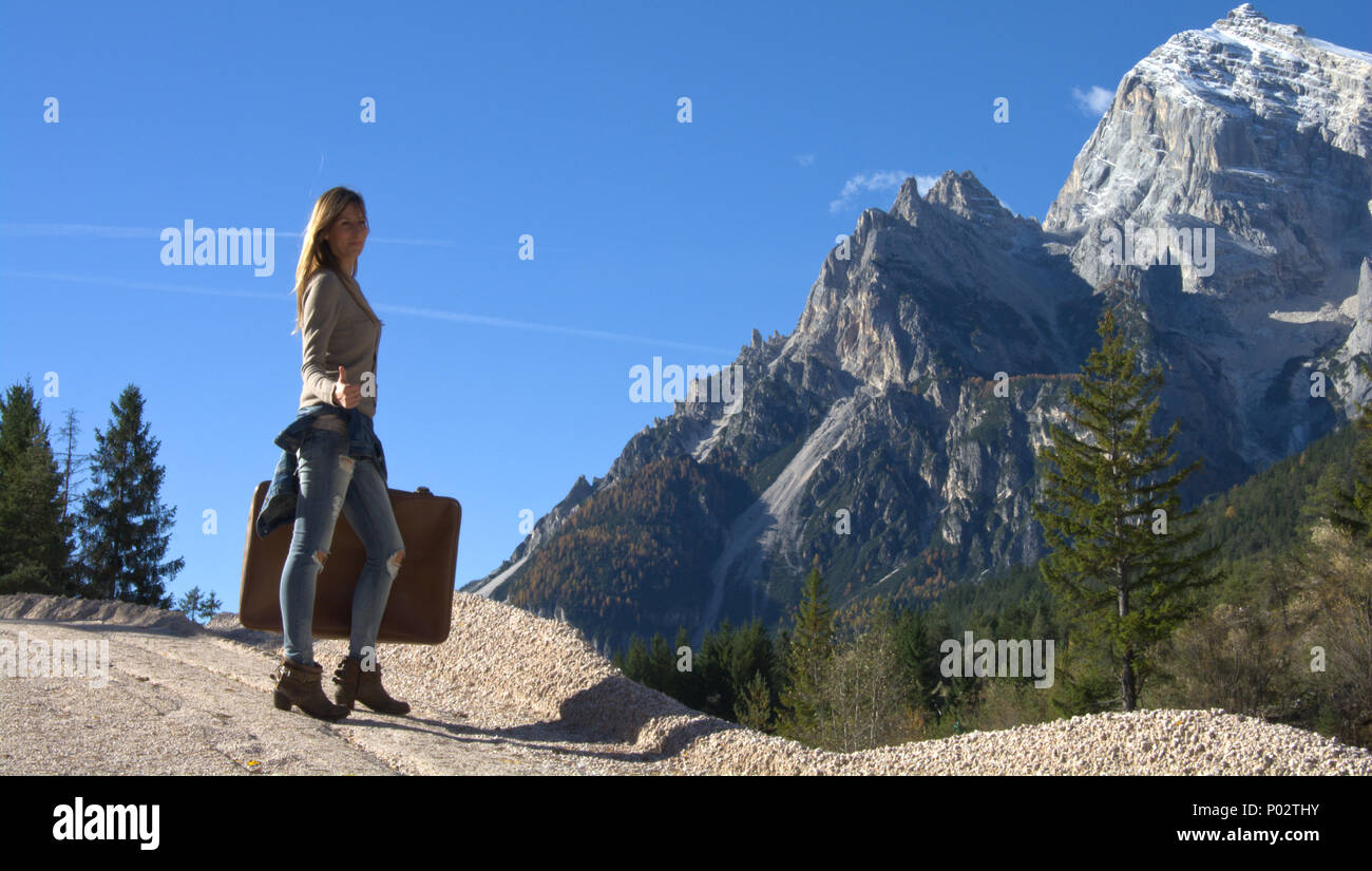 La ragazza con la valigia in montagna durante l'autunno Foto Stock