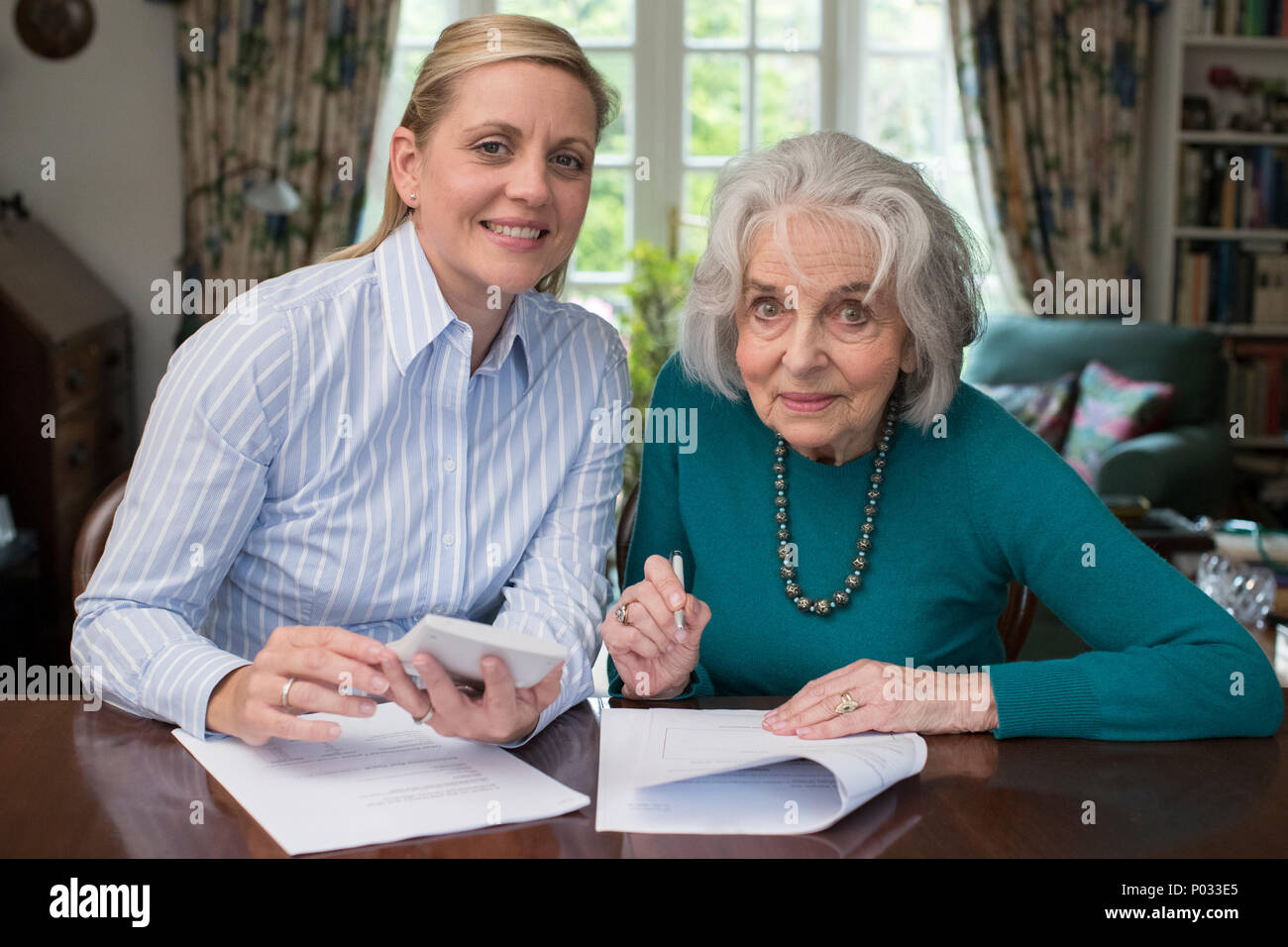 Ritratto di donna aiutando Senior confinante con la documentazione Foto Stock