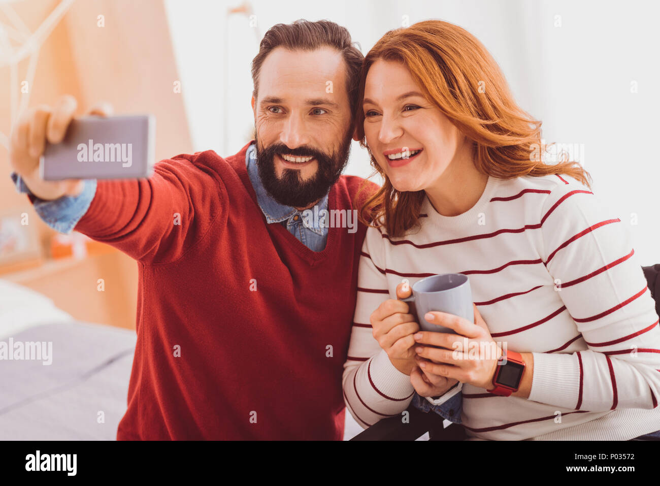 Dire il formaggio. Donna felice mantenendo il sorriso sul suo viso mentre si posa su telecamera Foto Stock