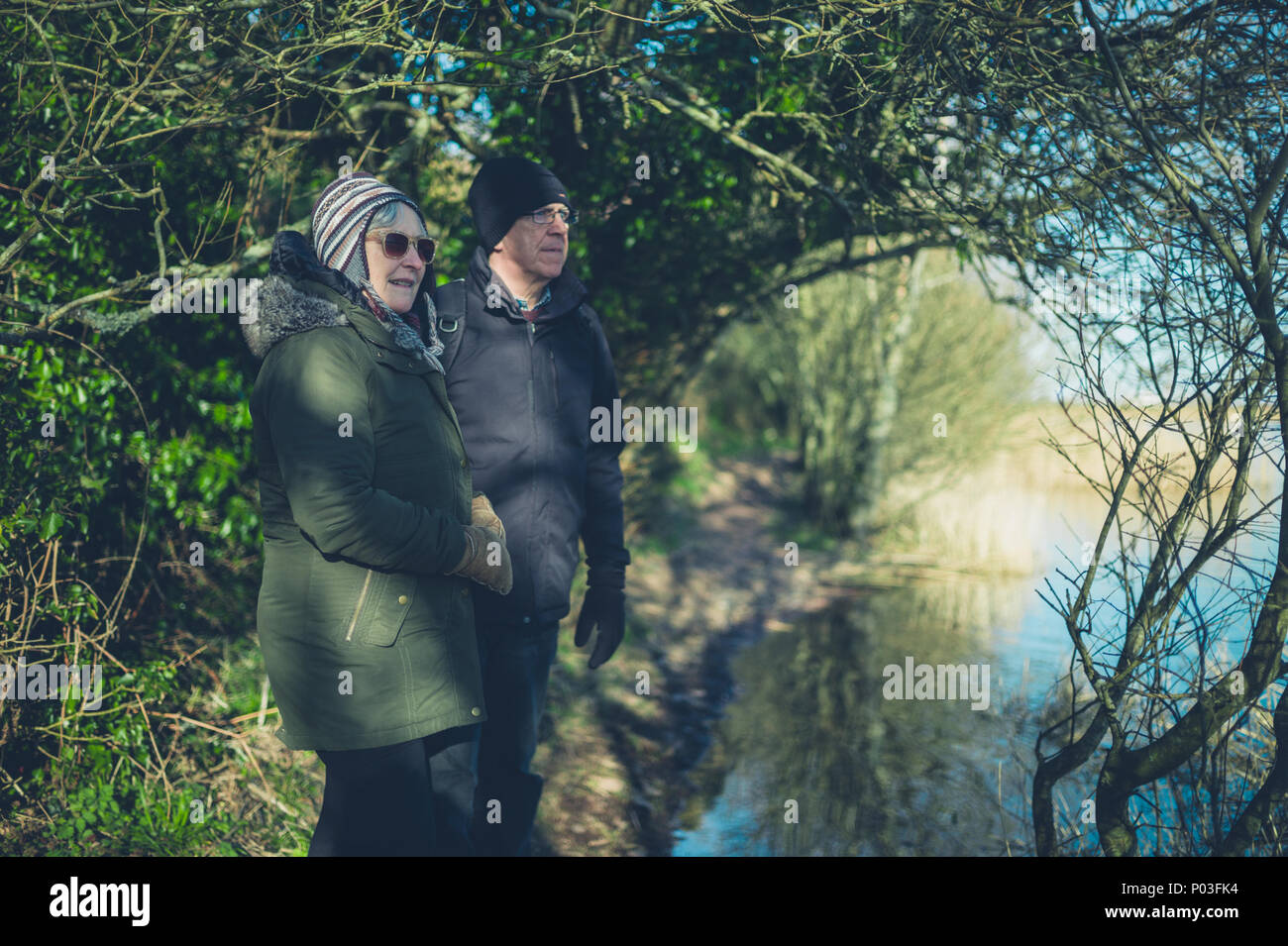 Una coppia senior godendo il pensionamento da un lago in inverno Foto Stock