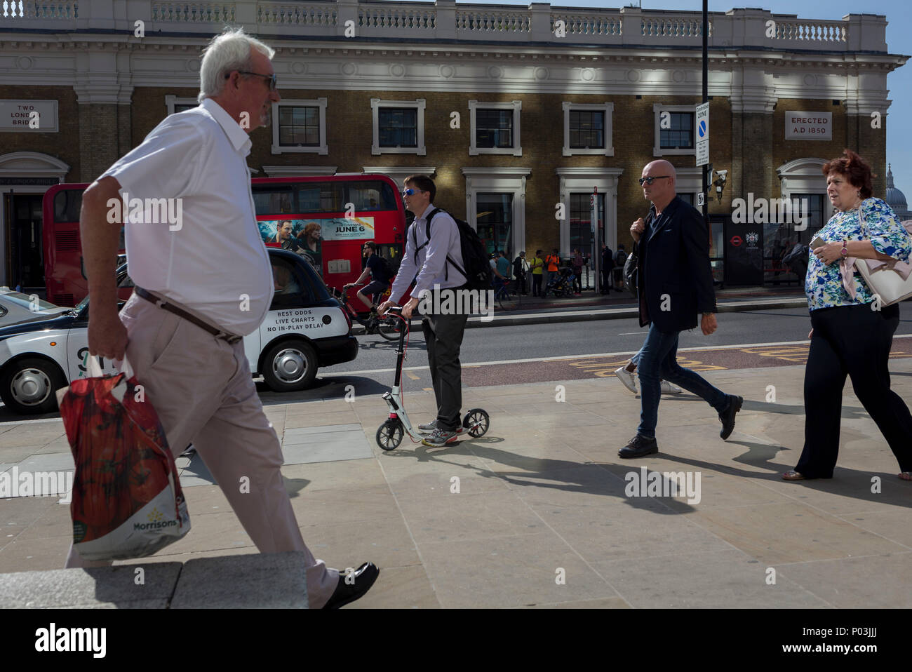 Pendolari e altri pedoni a piedi su London Bridge, la più antica della capitale attraversando il fiume Tamigi tra la capitale del distretto finanziario della City di Londra e la Southwark sulla banca del sud il 6 giugno 2018, a Londra, Regno Unito. Foto Stock