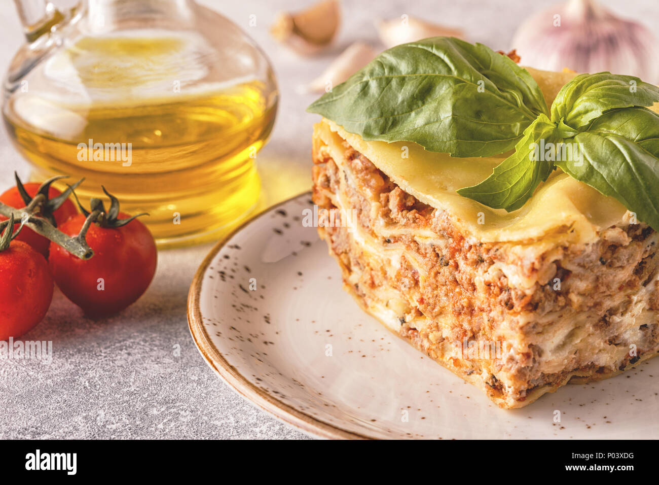 Lasagne tradizionali realizzati con le carni bovine macinate ragù alla bolognese e besciamella guarnita con foglie di basilico. Foto Stock
