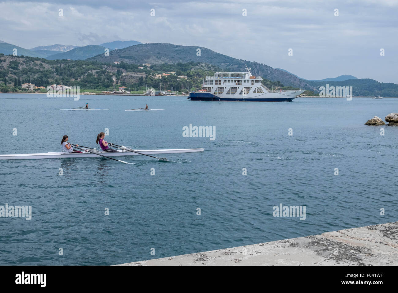 Traghetto locale e 2 persone in una piccola barca a remi. Foto Stock
