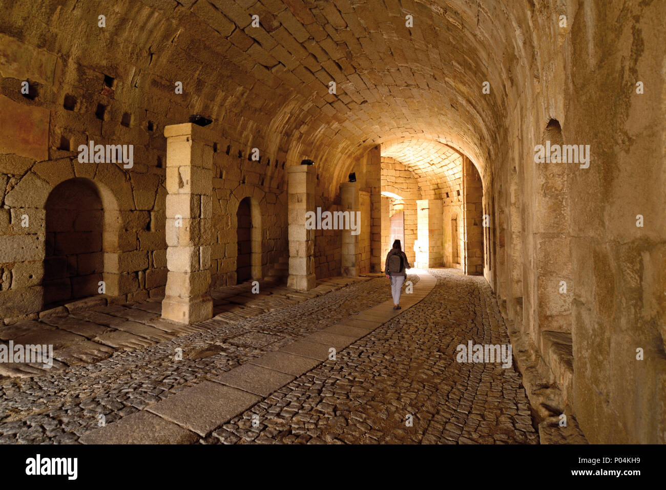 Donna che cammina in un tunnel fortificato verso l'uscita Foto Stock