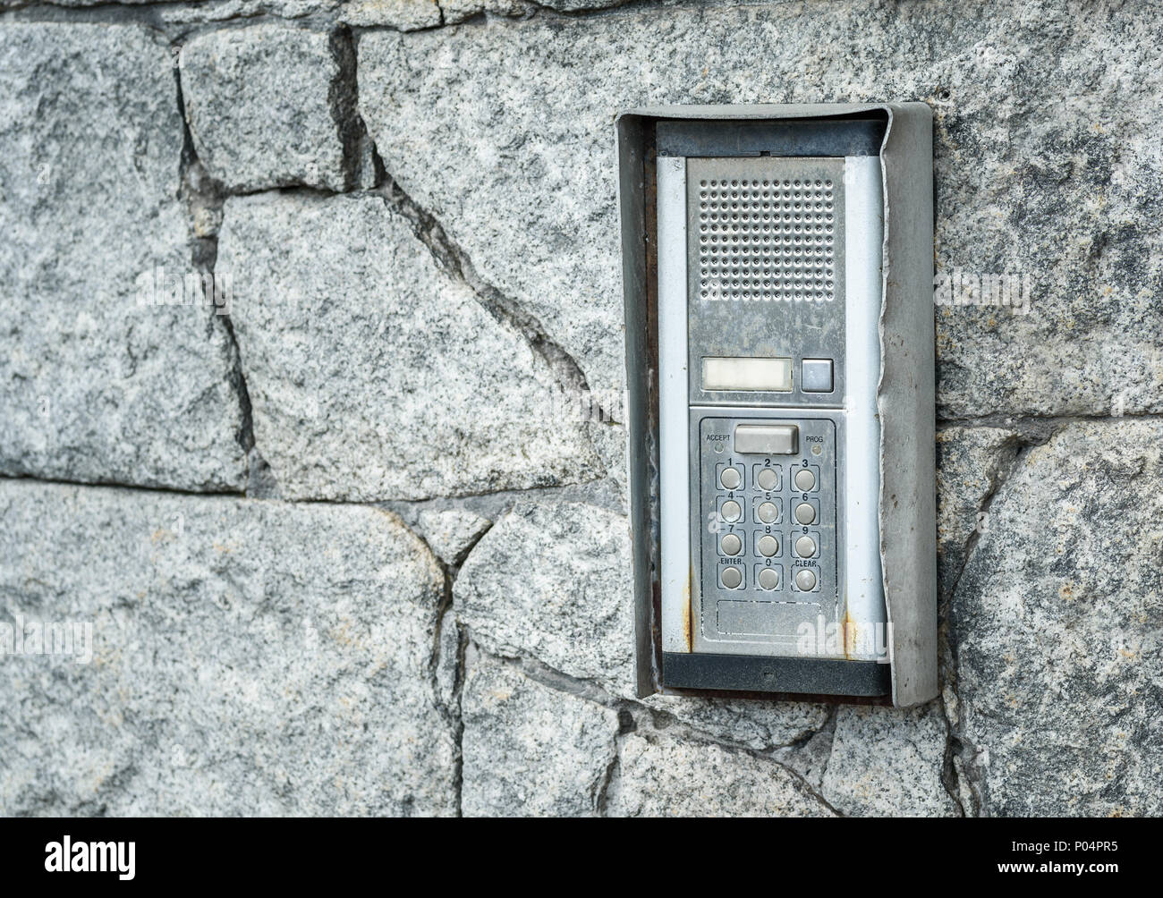 Un vecchio accesso intercom pad su un muro di pietra. Foto Stock