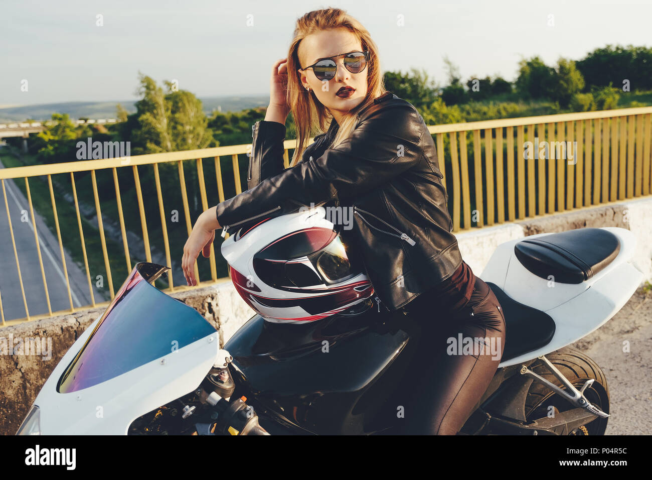 Bella donna con occhiali da sole di guida su moto Foto stock - Alamy
