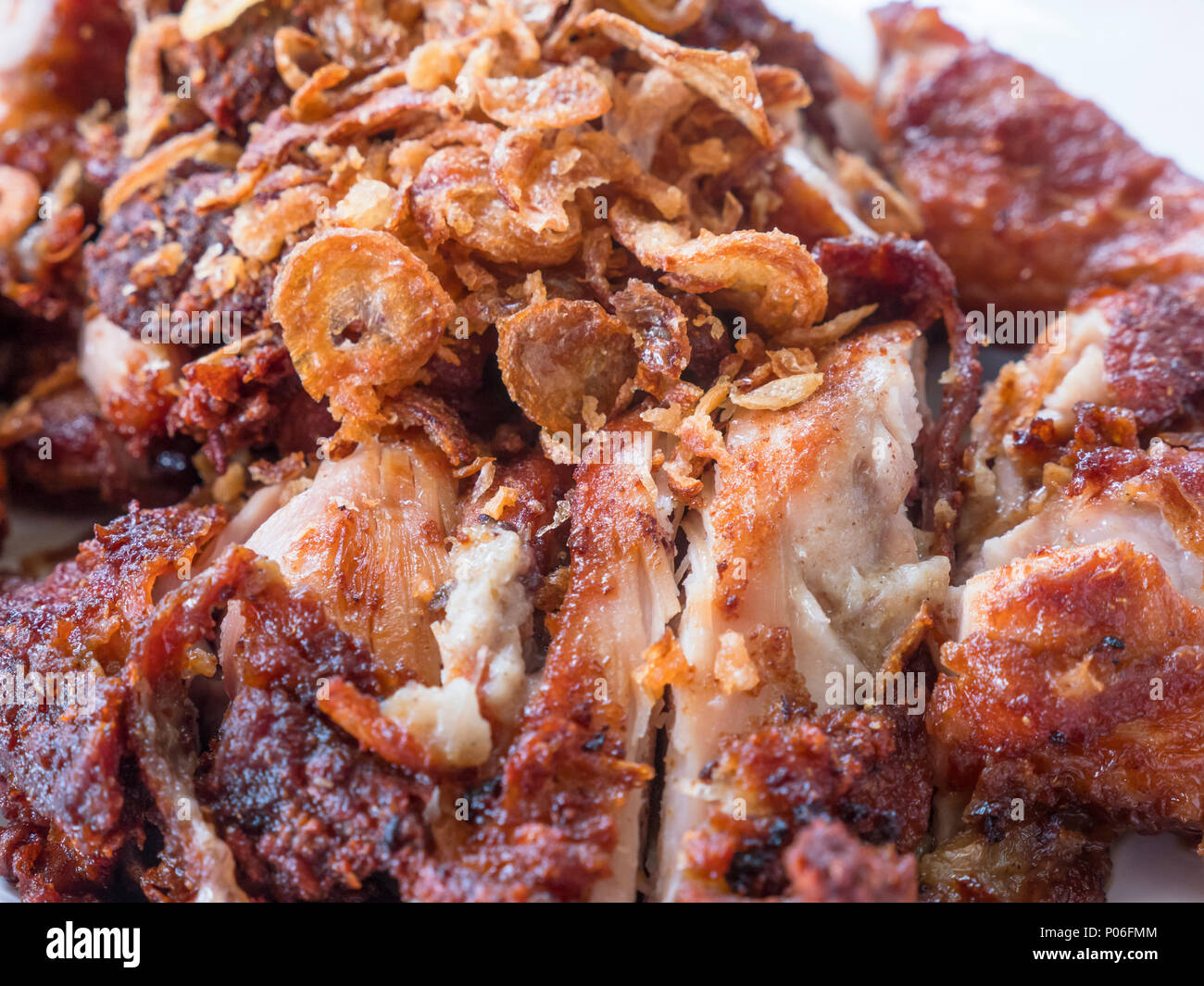 Croccante di stile Tailandese pollo grigliato, gai yang, con croccante di cipolla fritti. Profondità di campo. Foto Stock