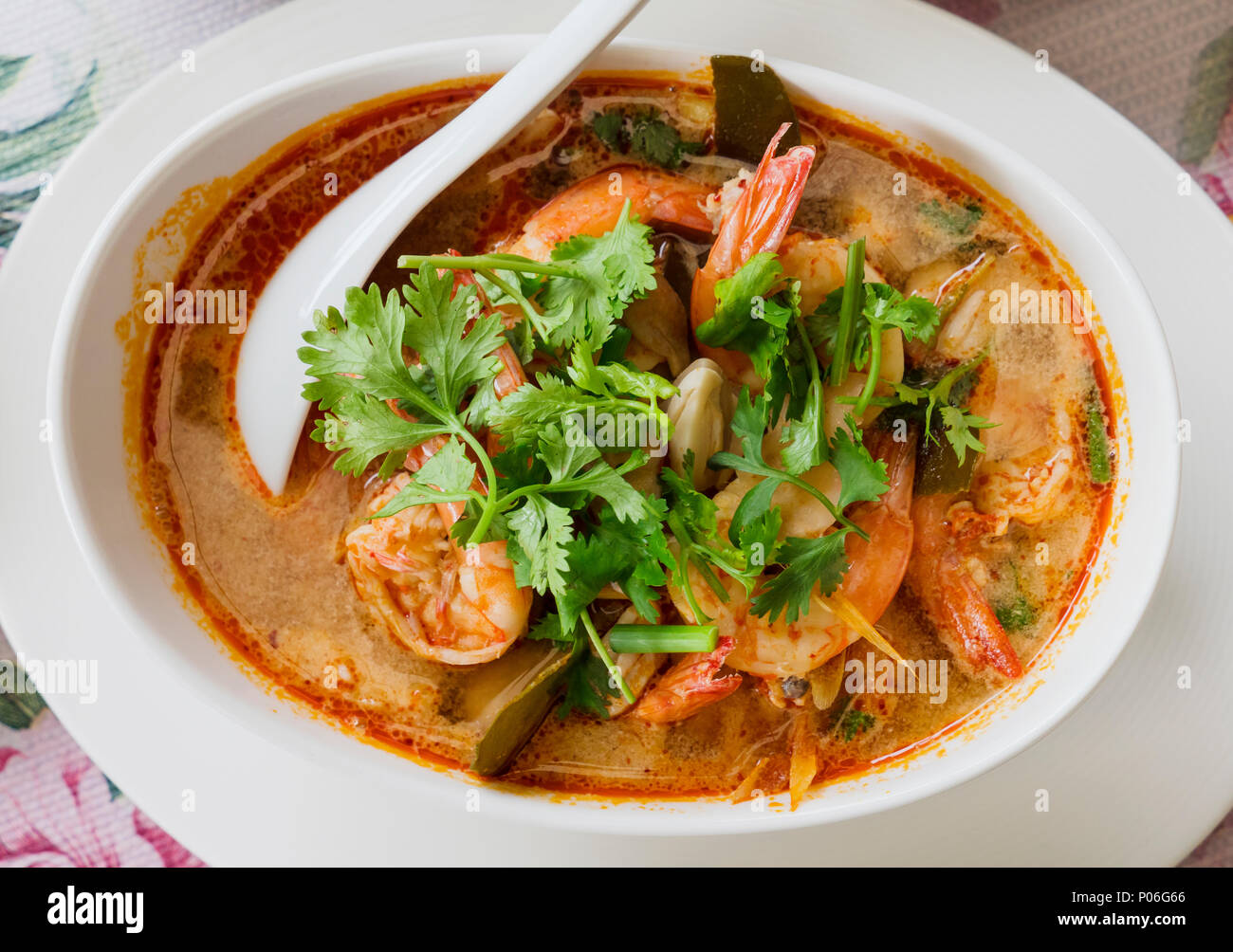 Tom Yam kung, il tailandese tradizionale minestra acida con gamberetti e champignon, guarnita con coriandolo. La foto mostra la versione rossa di zuppa, fatta wit Foto Stock