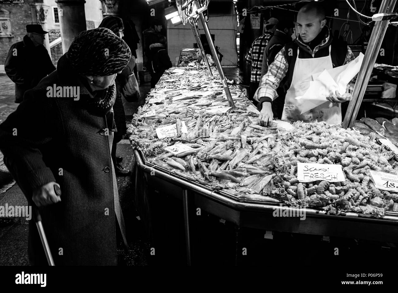 Una donna anziana l'acquisto di pesce fresco dal mercato, Venezia, Italia Foto Stock