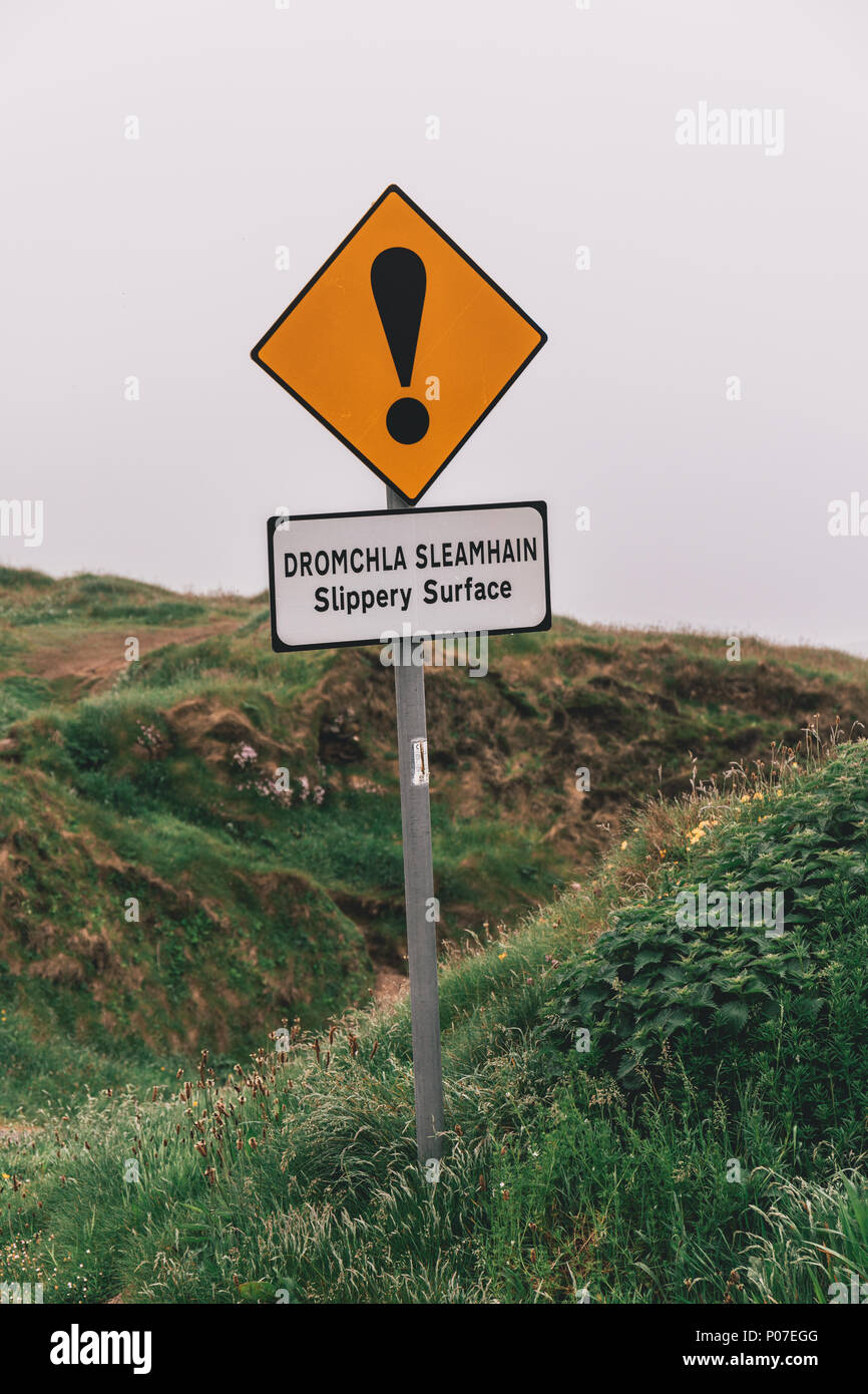 Giugno 5th, 2018 a Dunquin, Irlanda - segni premonitori di superficie scivolosa e bordi non protetti all'iconico Dunquin molo del porto di frazioni Foto Stock