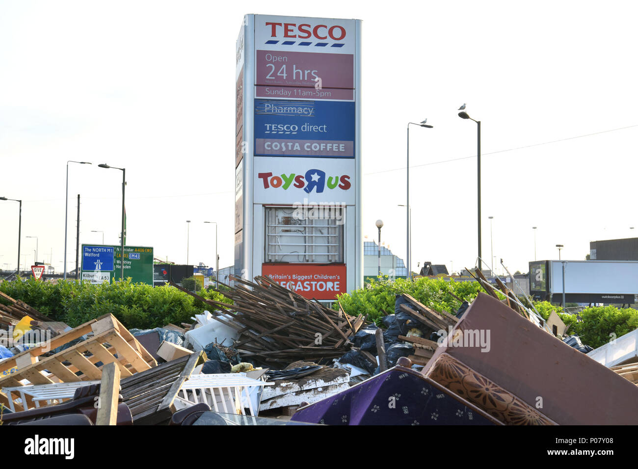 Volare il ribaltamento di spazzatura è a sinistra nella parte anteriore del negozio di segni comprendenti Tesco Direct e il Toys R Us sia ormai chiuso negozi, sulla North Circular, vicino th Foto Stock